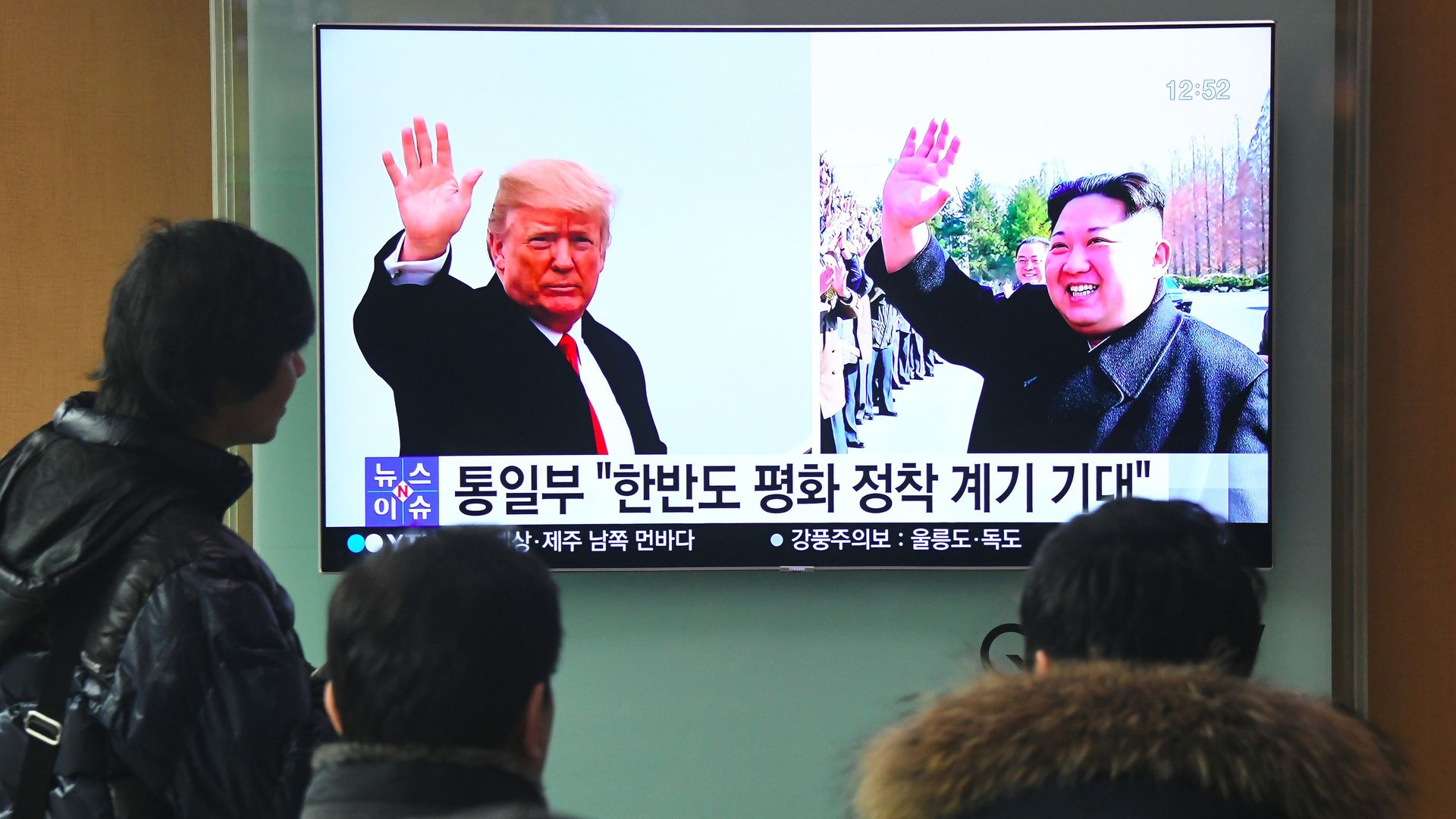 TV in Seoul train station showing Trump and Kim waving in separate photos
