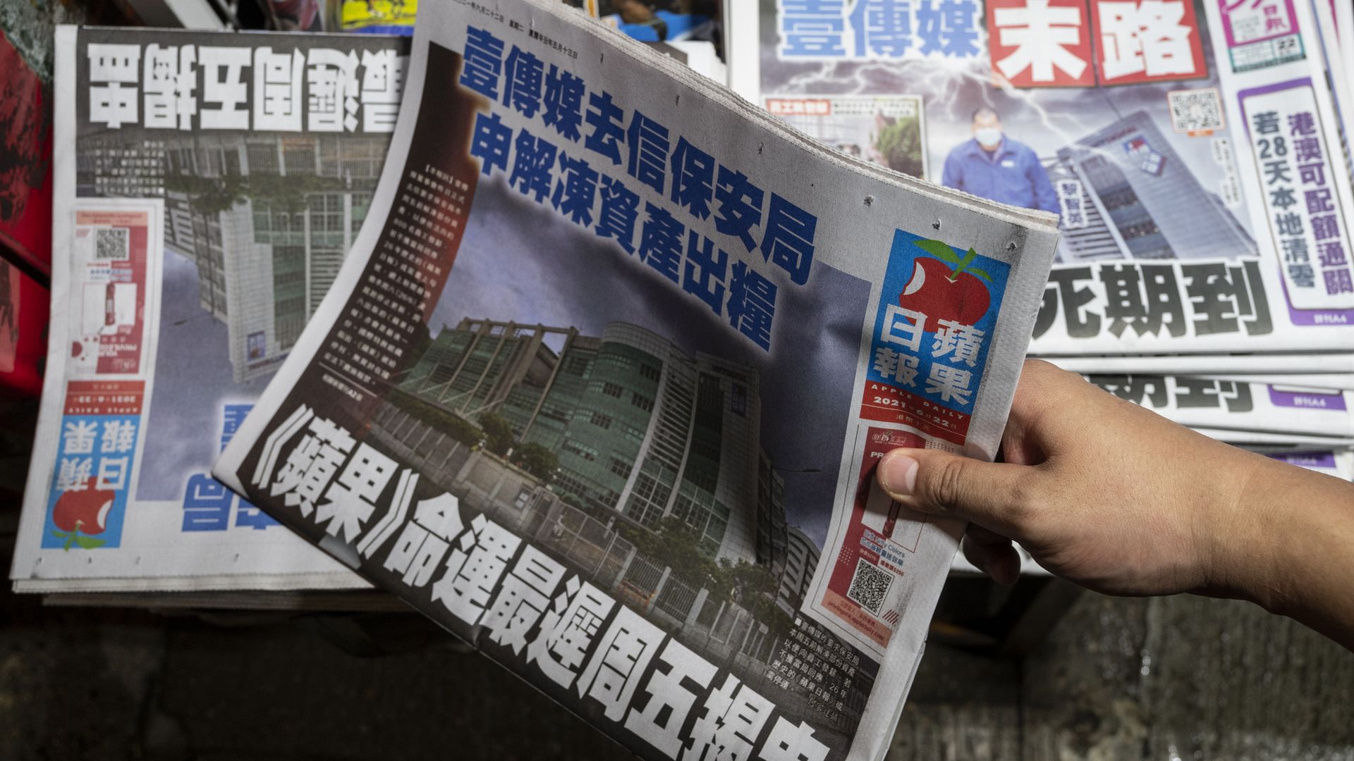 A customer grabs a copy of Apple Daily newspaper at a newsstand in Hong Kong on June 22, 2021.