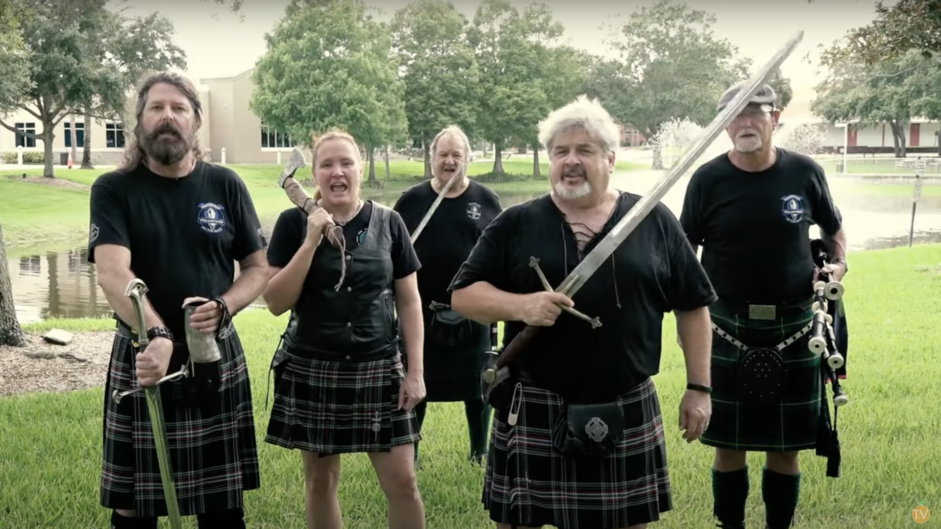 A group of people dressed in kilts and holding swords 