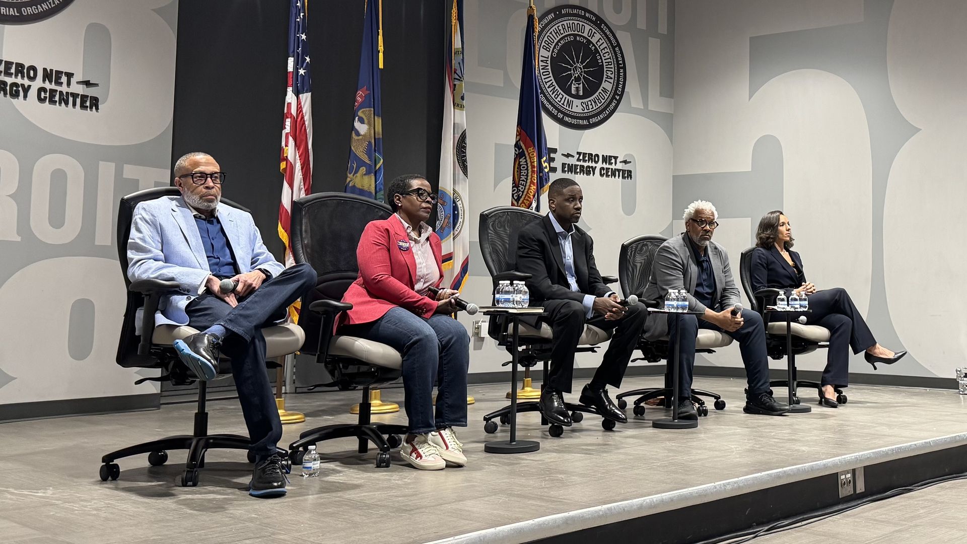 The candidates sit on stage
