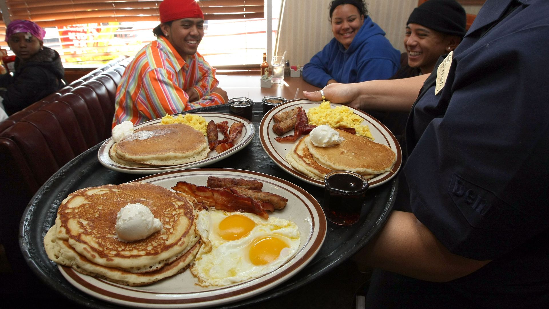 A Denny's waitress delivers breakfasts to customers.