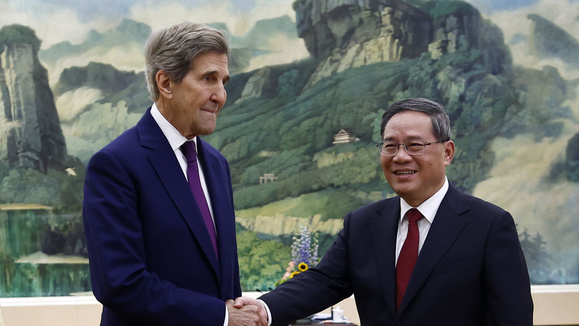 U.S. climate envoy John Kerry (L) is greeted by Chinese Premier Li Qiang for climate talks in Beijing.