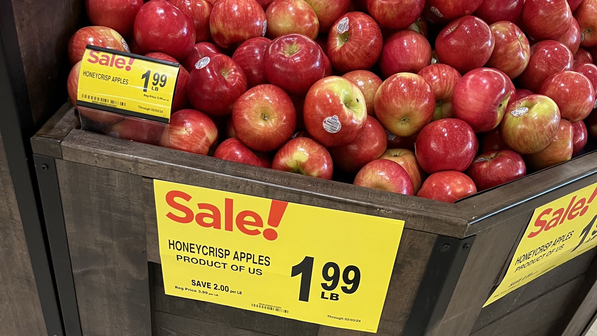 A display of honeycrisp apples advertising $1.99 per pound, a savings of $2 per pound