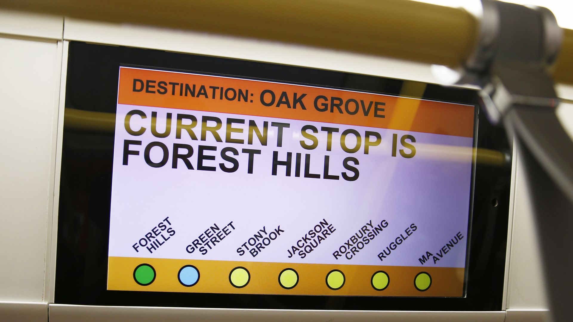 An LCD screen on the T shows the stops on the Orange Line, from Forest Hills to the destination of Oak Grove. 