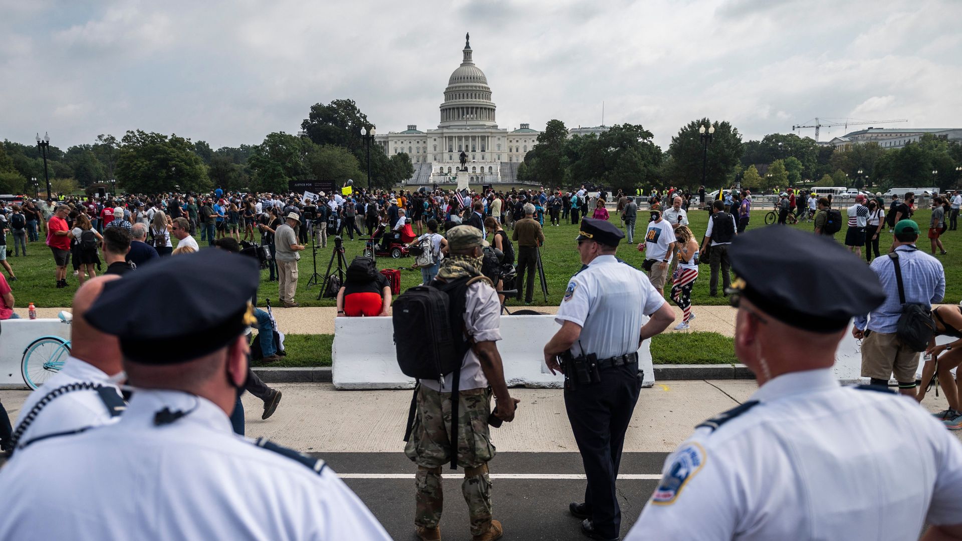 Police officers watch as demonstrators gather for the "Justice for J6" rally in Washington, DC, on September 18, 2021,