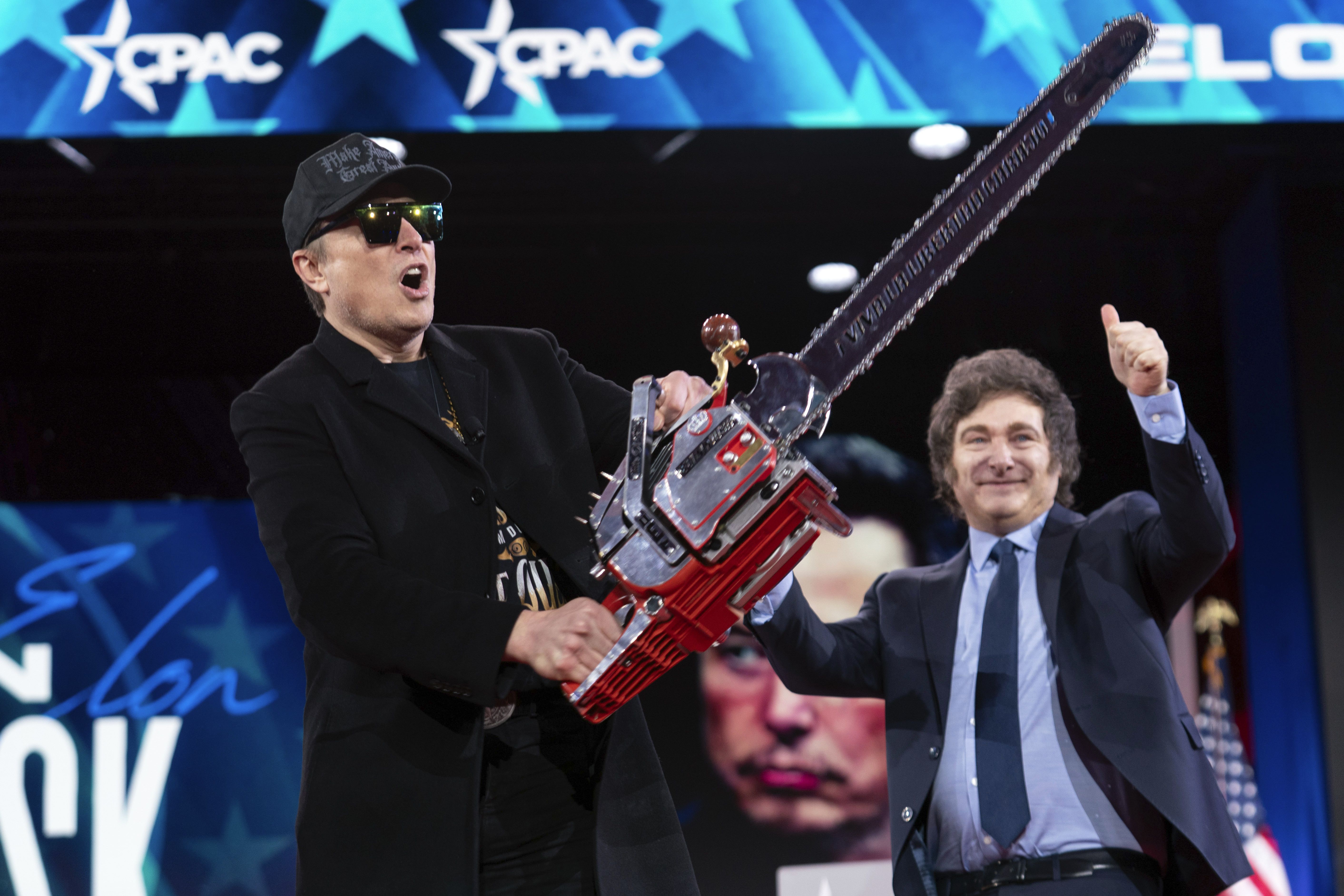 Elon Musk waves a chainsaw he received from Argentine President Javier Milei at CPAC yesterday.