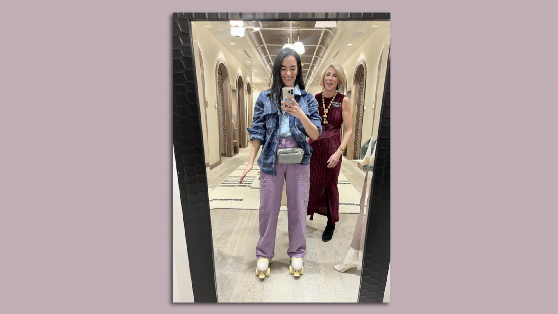 Axios Charlotte reporter Laura Barrero stands in front of a mirror with a new outfit on.