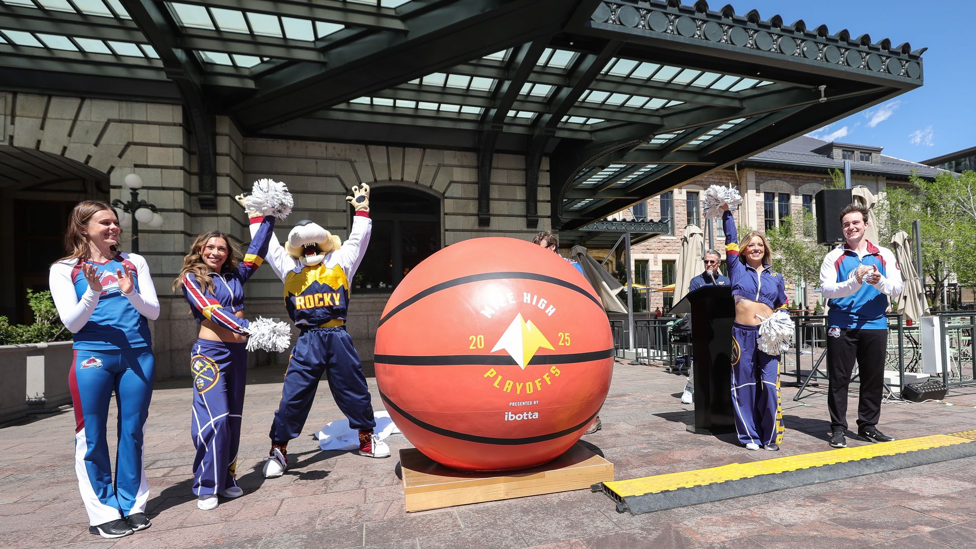 A giant basketball surrounded by cheerleaders, including the Denver Nuggets mascot. 