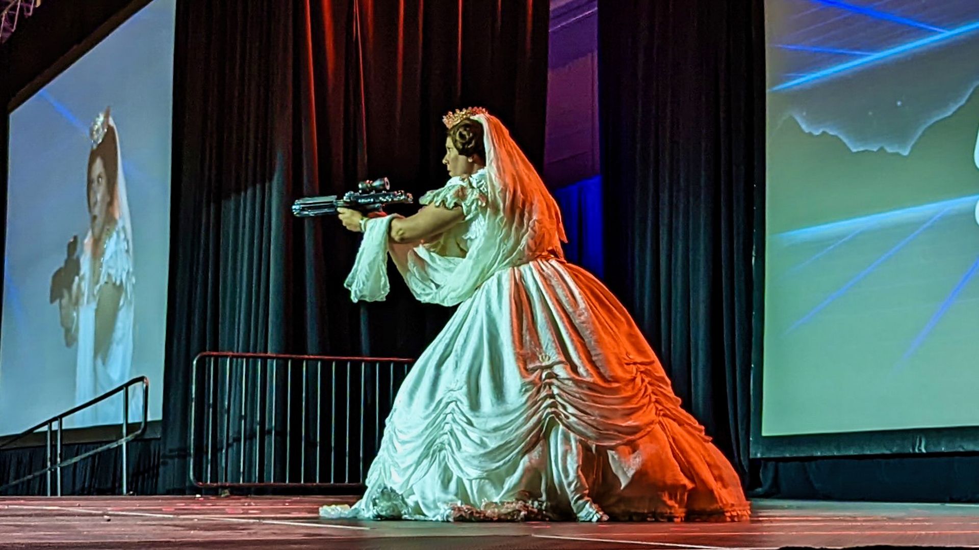 A woman is firing a blaster gun costumed as Princess Leia but with Victorian fashion stylings.