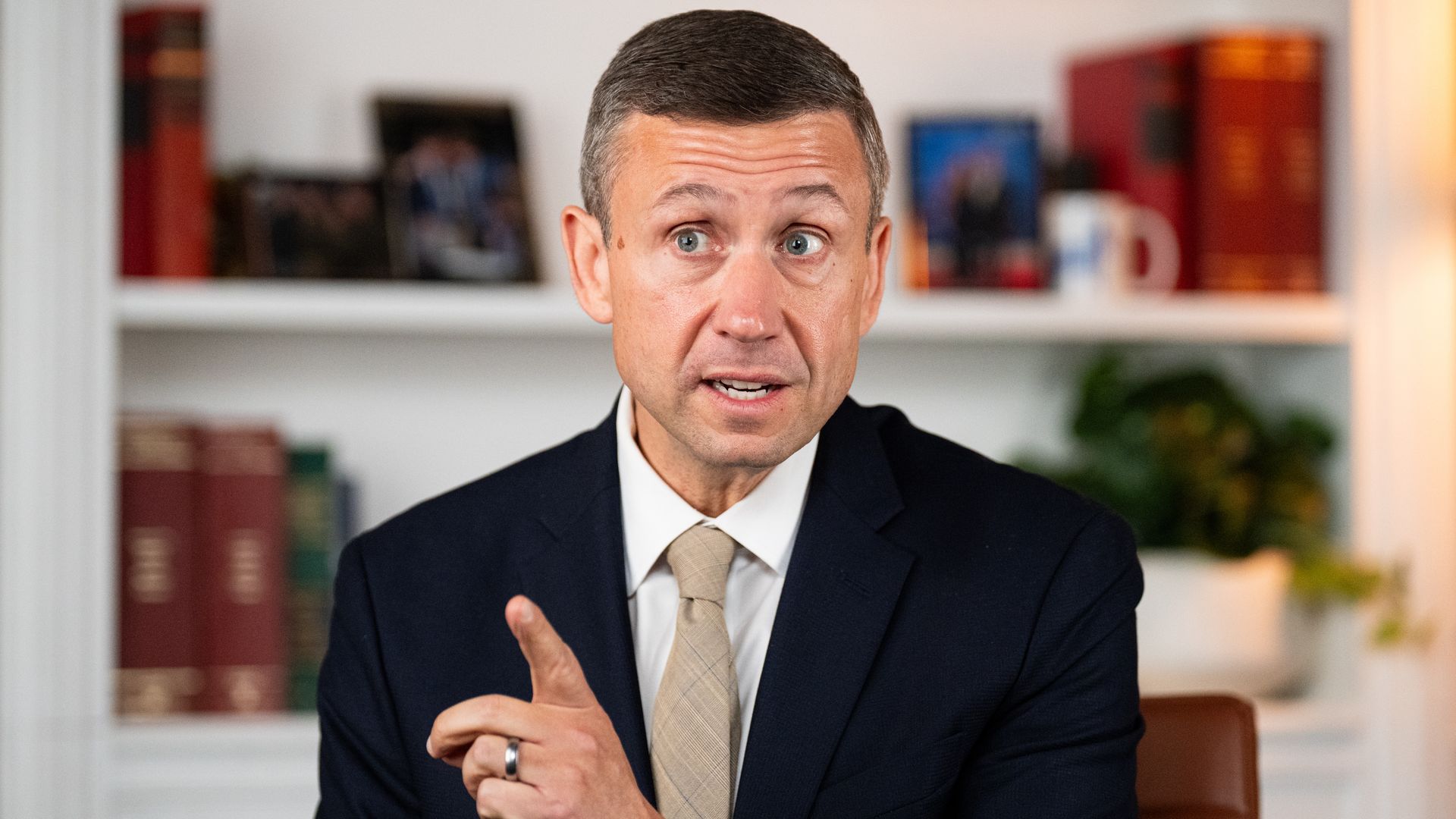 Image shows Ken Martin wearing a suit and gesturing.