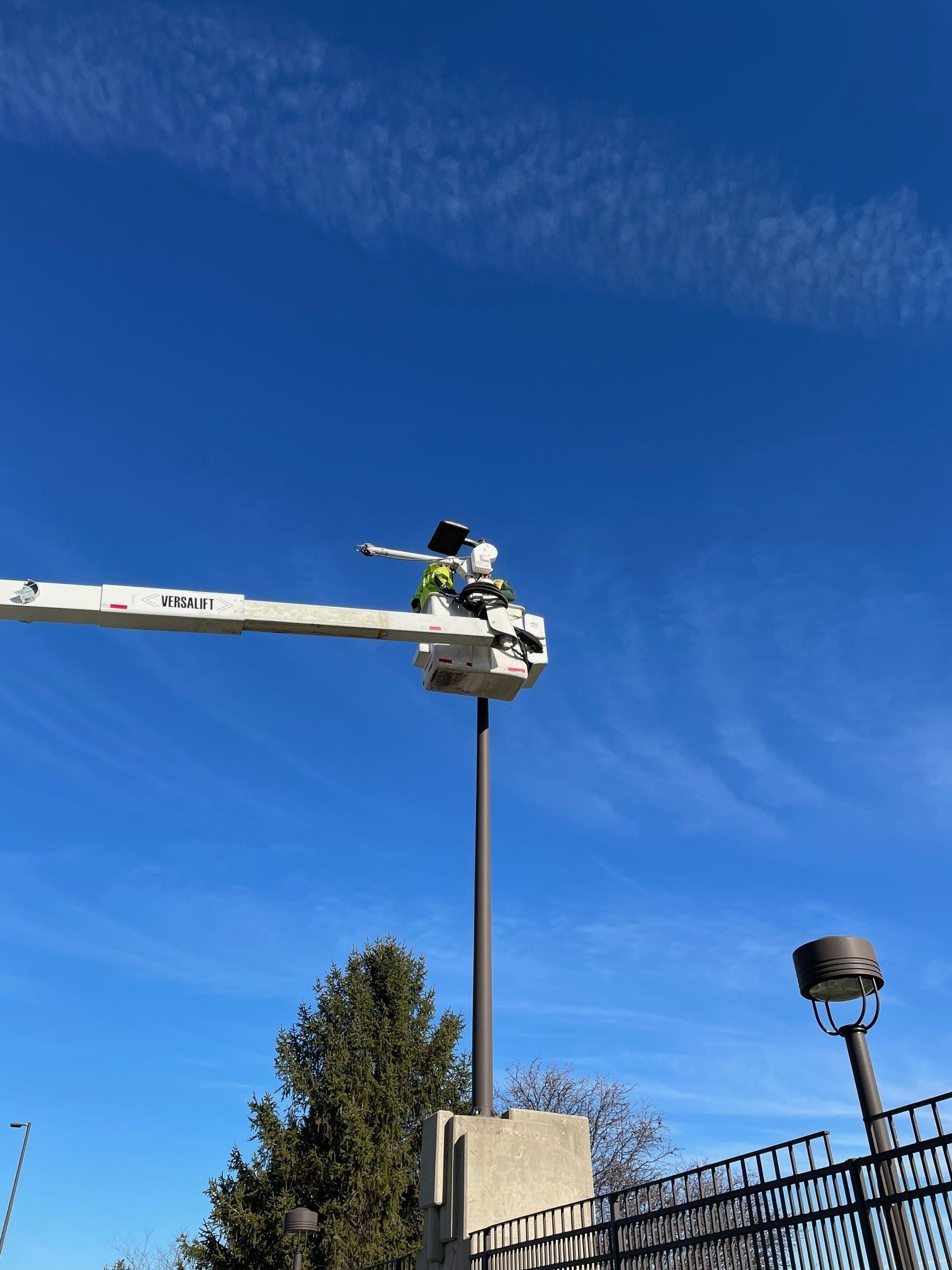 Dublin city workers in a crane bucket install a weather camera in the air. 