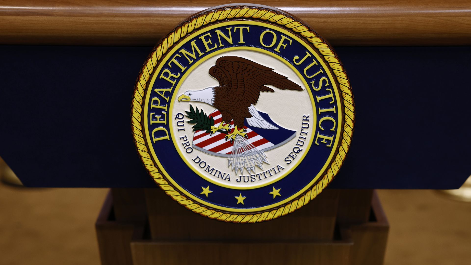 A seal for the Department of Justice is seen on a podium ahead of a news conference.