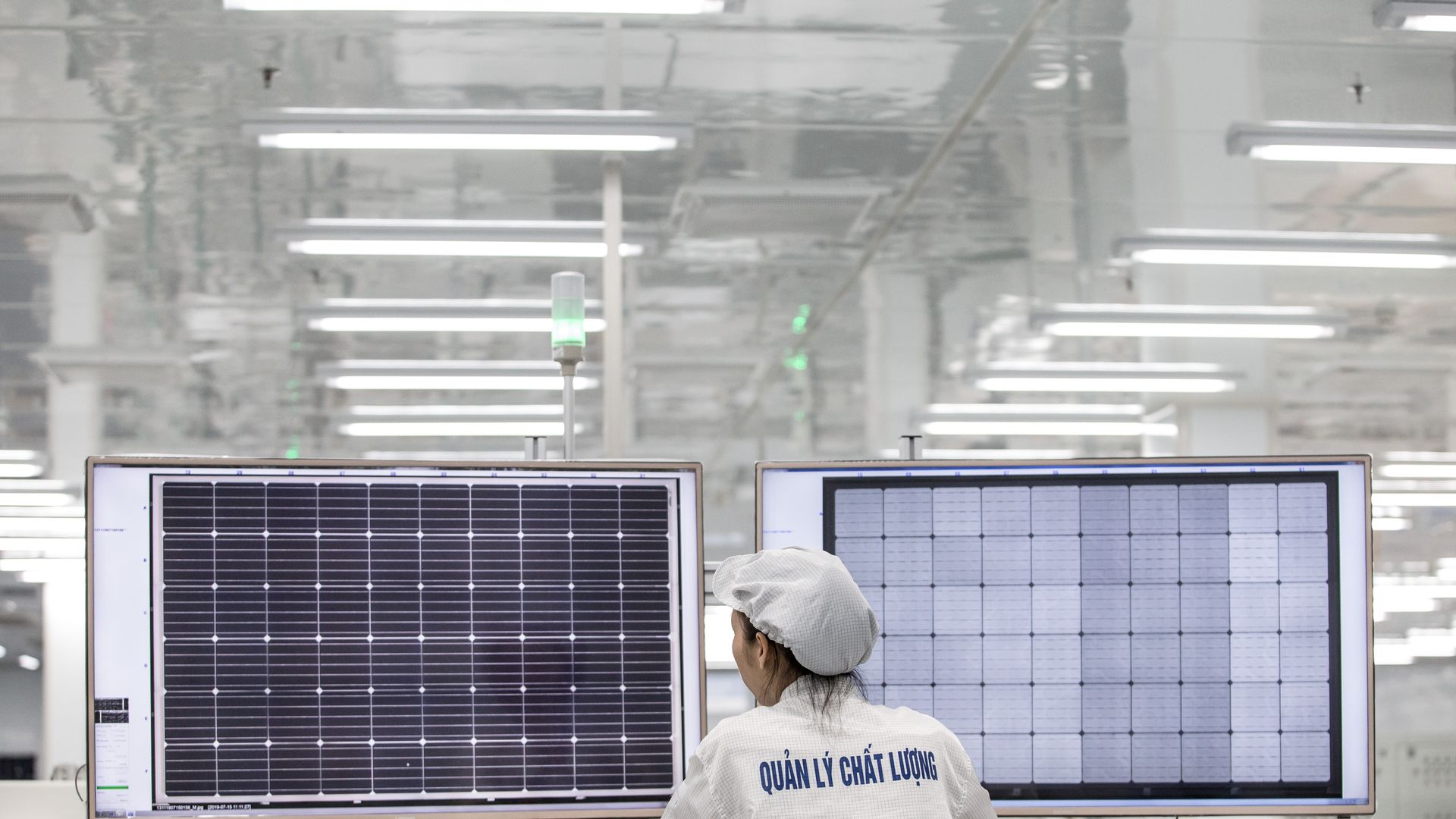 Worker at Vietnam solar factory inspects panels