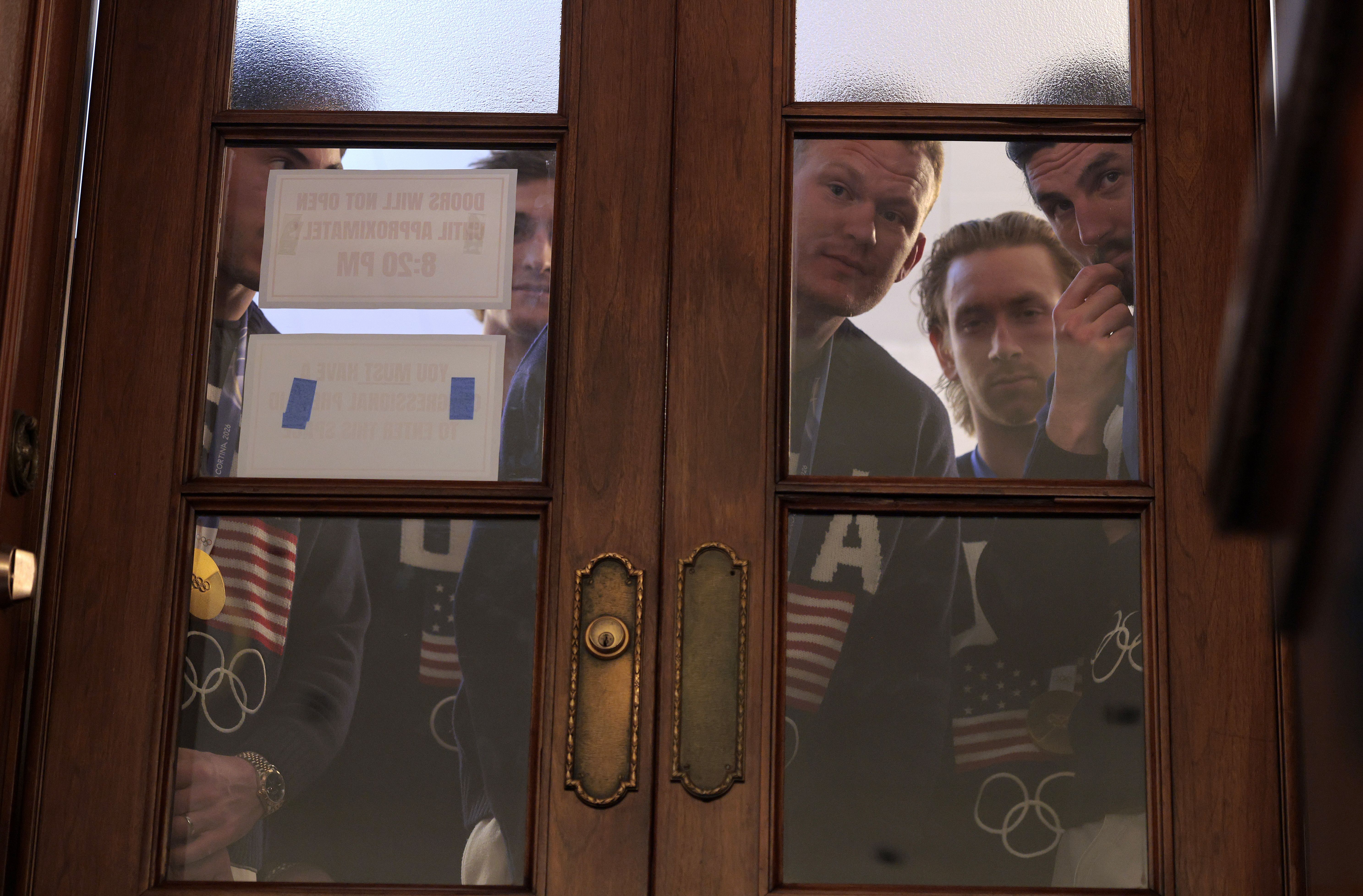 Members of the gold-medal winning Olympic hockey team — including goalie Connor Hellebuyck (right) — wait to enter the House chamber during President Trump's address. 
