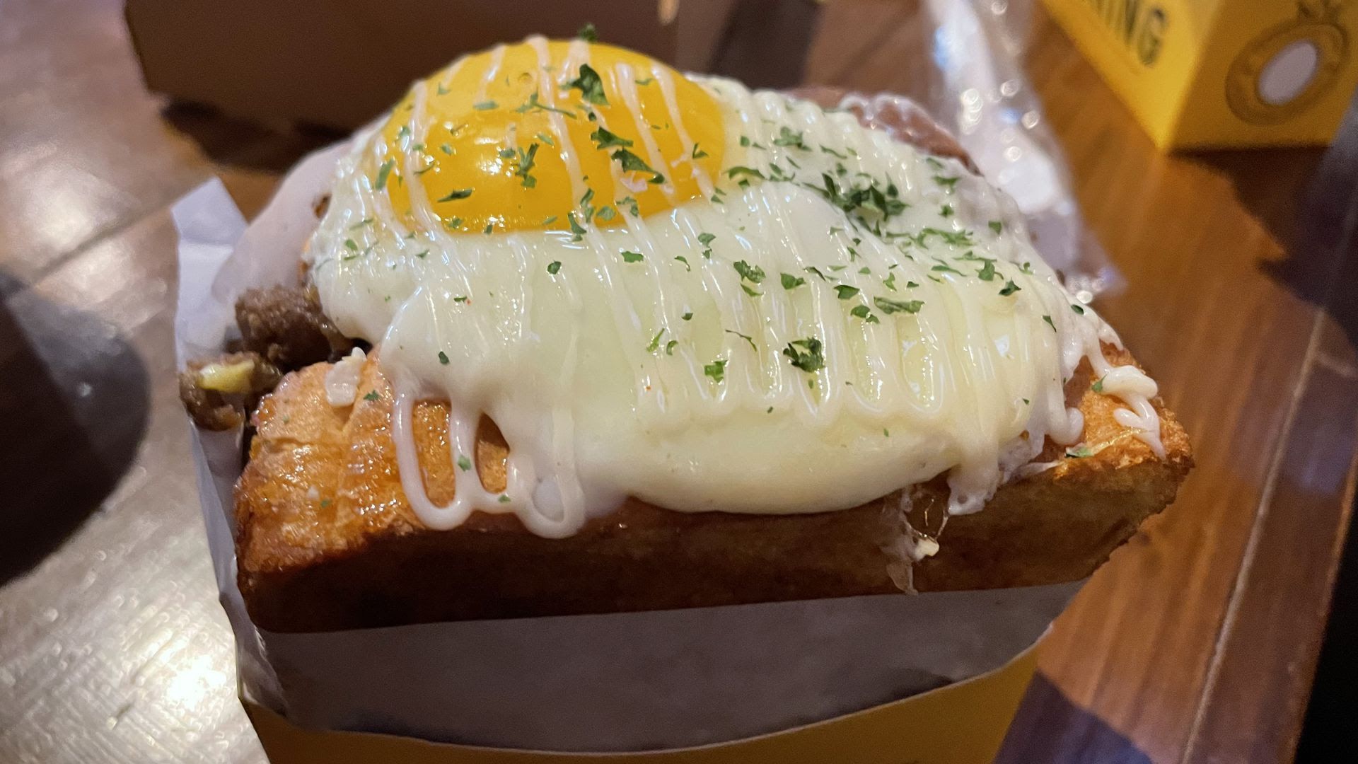 An "EggGogi" sandwich with scrambled eggs, bulgogi, a sunny-side up egg, house sauce and Texas toast.