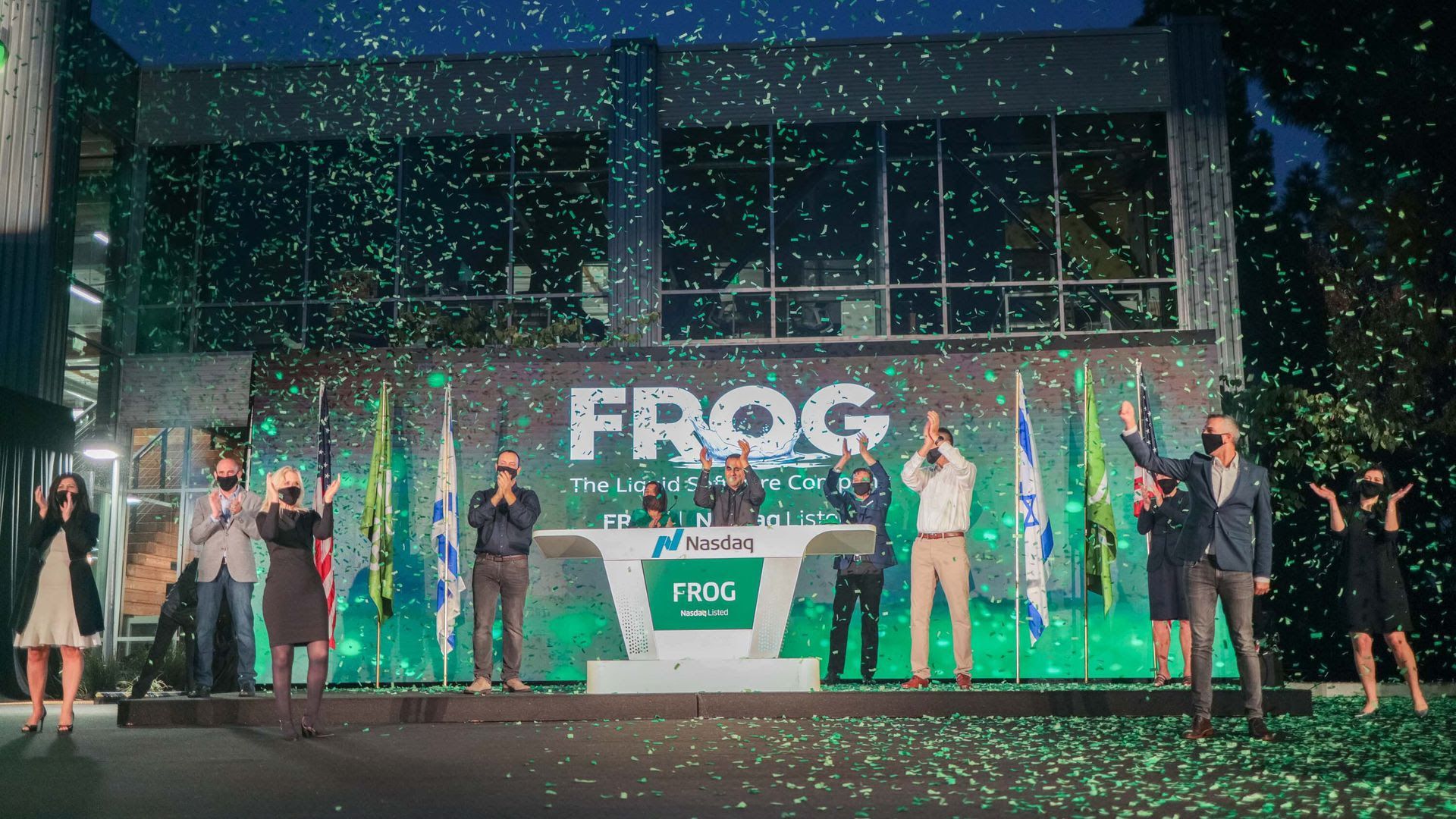 Frog celebrating their IPO under a banner and confetti.
