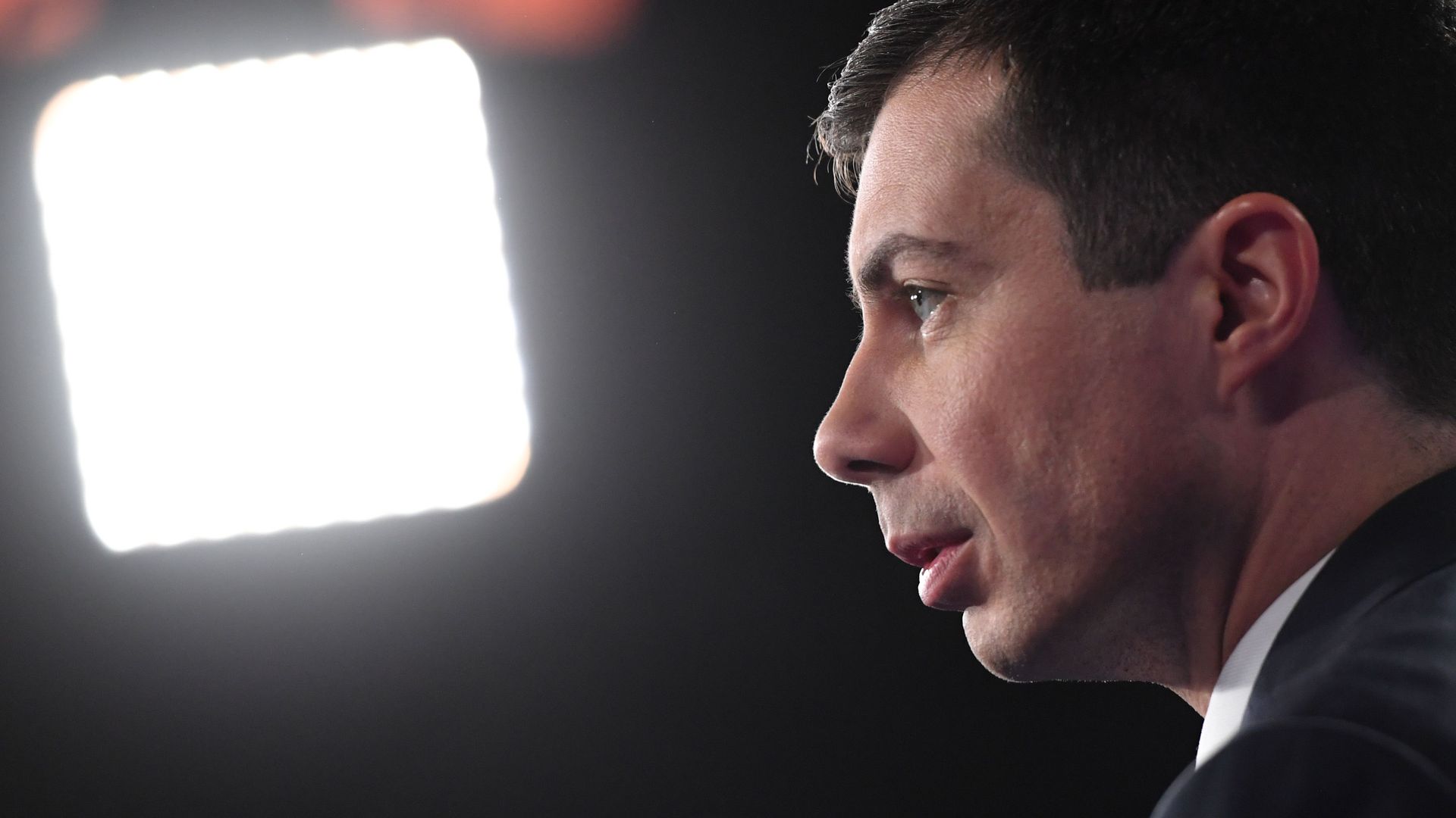 In this image, Pete's face is seen from the side as he sits in front of a TV spotlight.