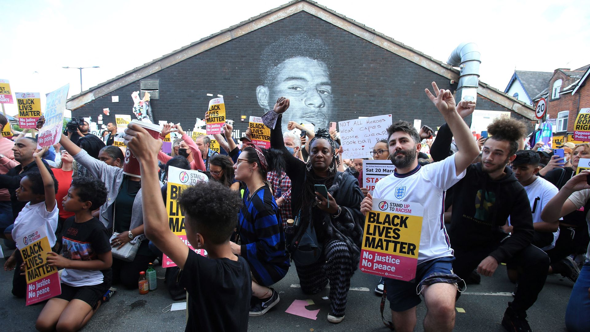 Anti-racism protestors demonstrate by a mural of England forward Marcus Rashford after it was defaced on July 13, 2021 in Manchester,
