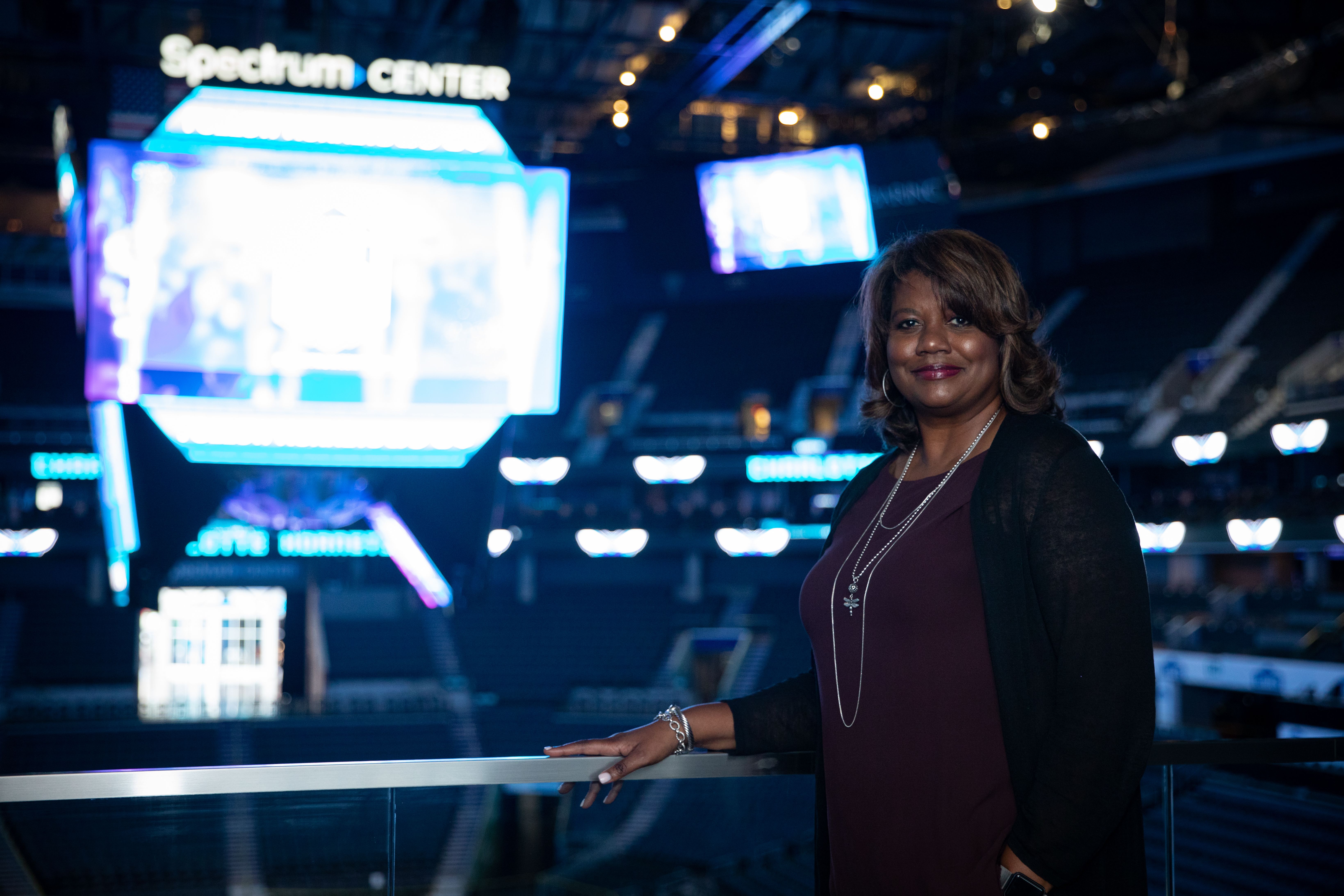 Donna Julian stands in front of the jumbotron at Spectrum Center. 