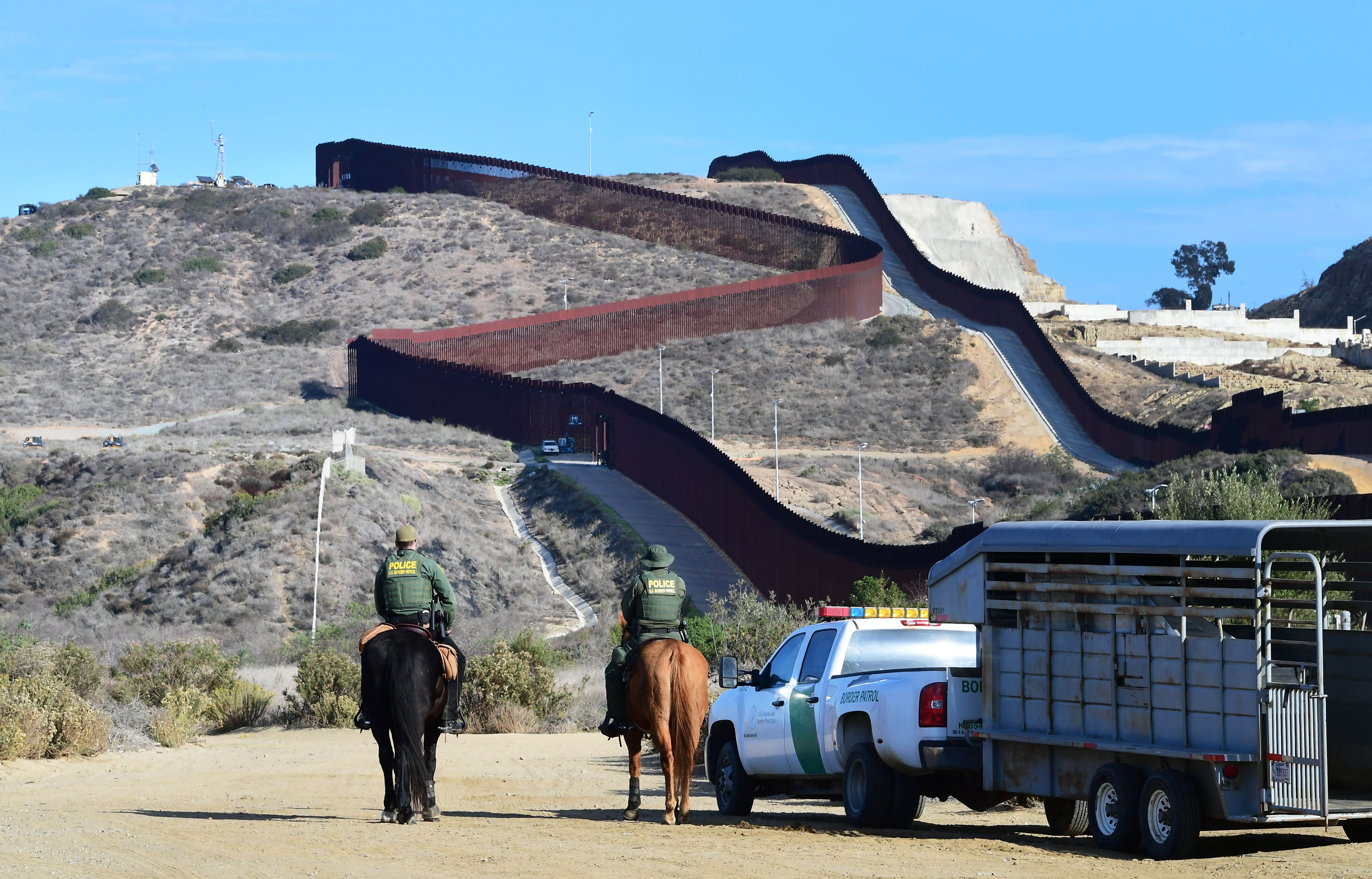 US Homeland Security Border Patrol agents on horseback patrol the area near where the US-Mexico border fence meets the Pacific Ocean in Imperial Beach, California, on November 7