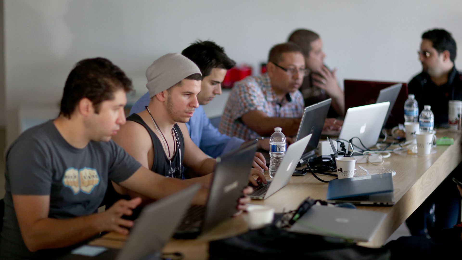 computer programmers working on laptops at a table
