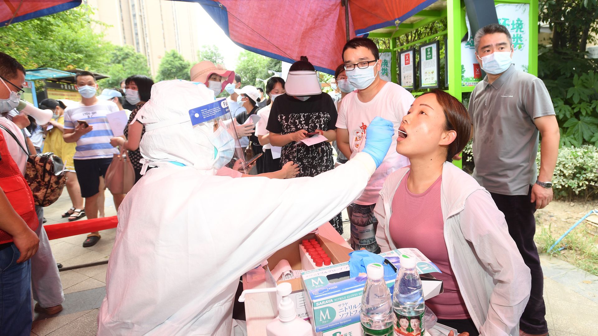 A medical worker takes samples for the mass Covid-19 test in a residential block in Wuhan