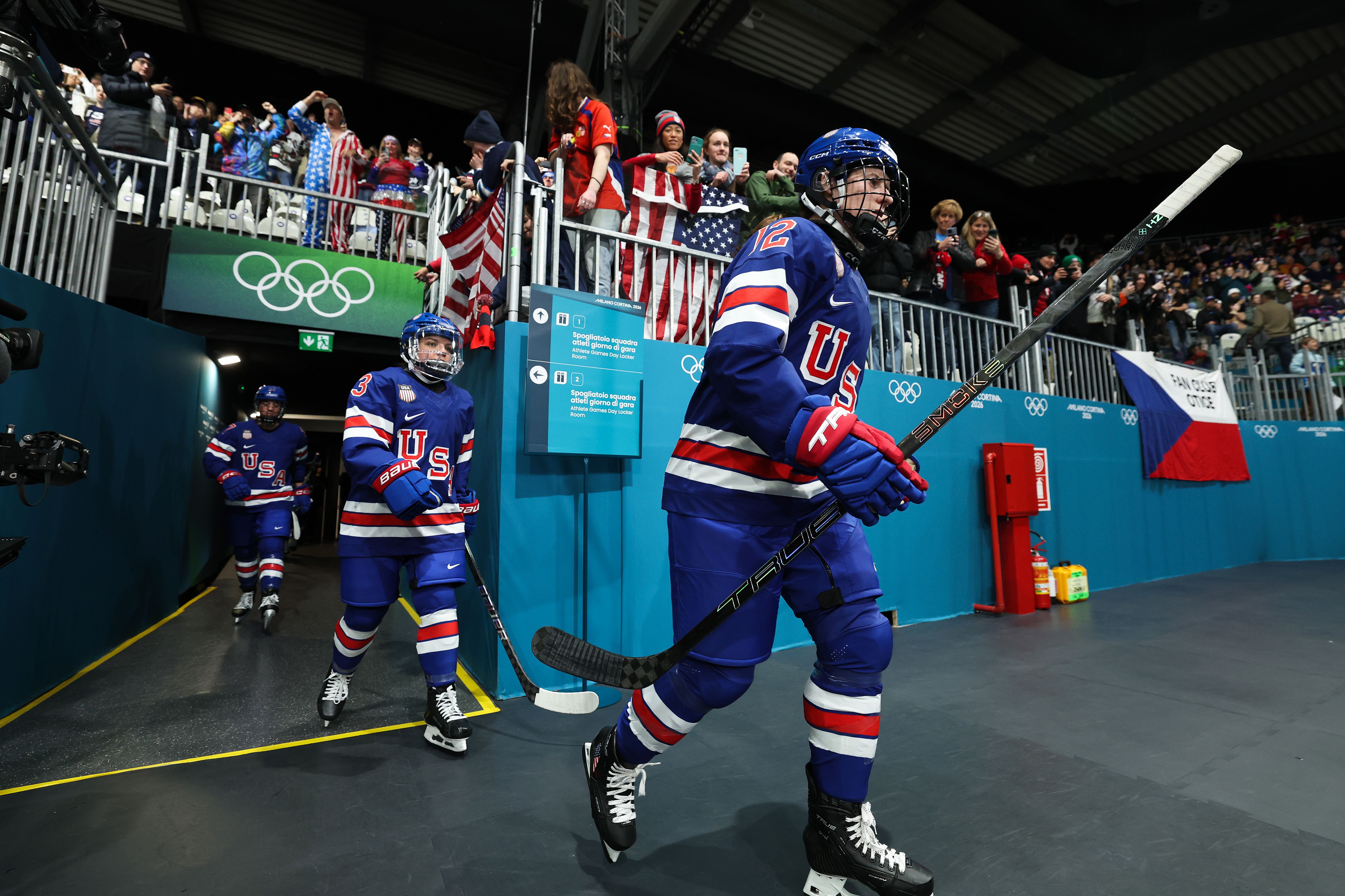 Kelly Pannek (R) #12 and Cayla Barnes #3 (C) of Team United States enter the rink prior to the Women's Preliminary Round Group A match between the United States and Czechia on Day minus one of the Milano Cortina 2026 Winter Olympic games at Milano Rho Ice Hockey Arena on February 05, 2026 in Milan.
