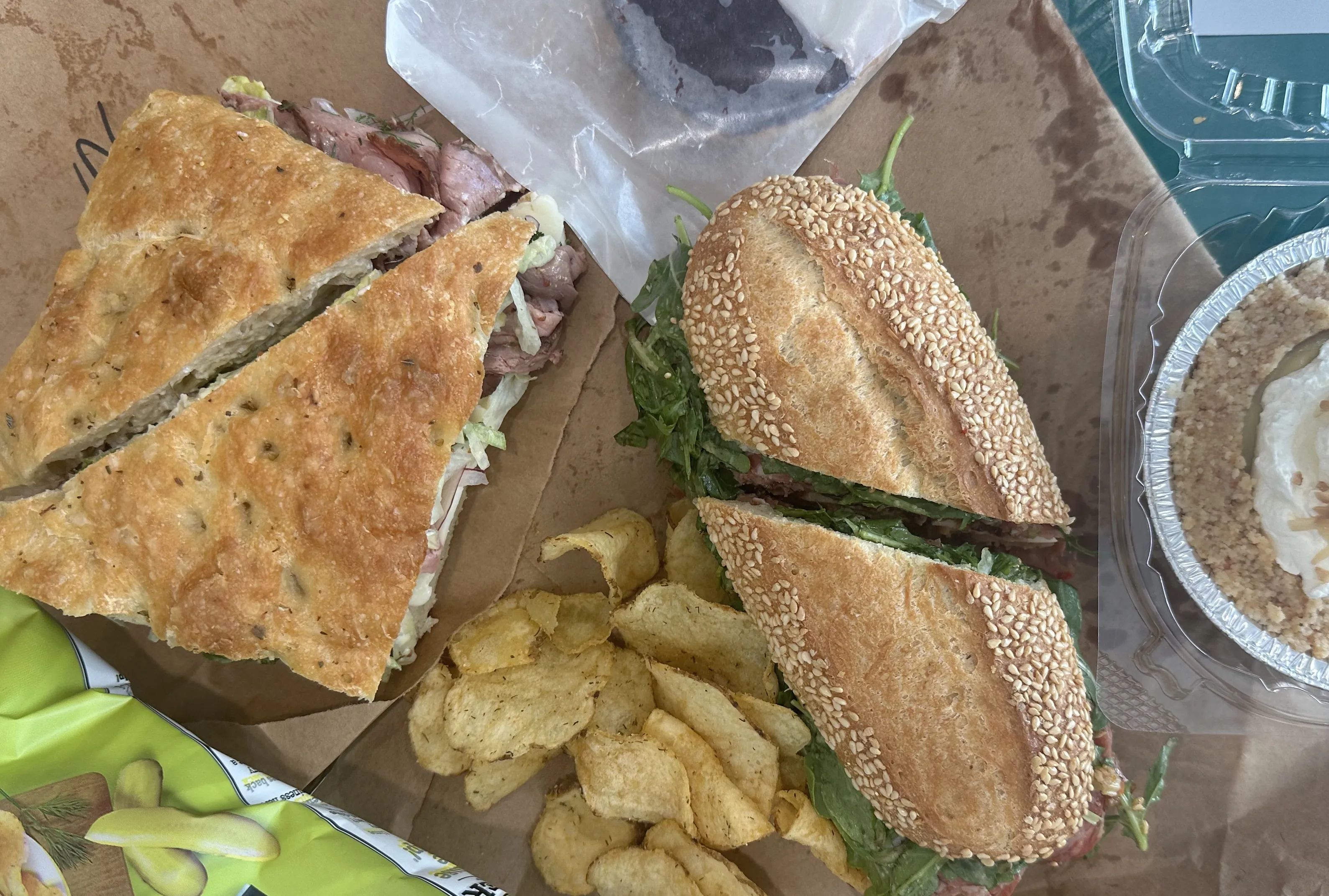 Photo shows sandwiches and chips on brown butcher paper