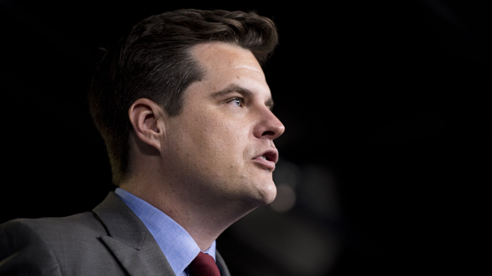 In this image, Gaetz stands and looks to the right while speaking.