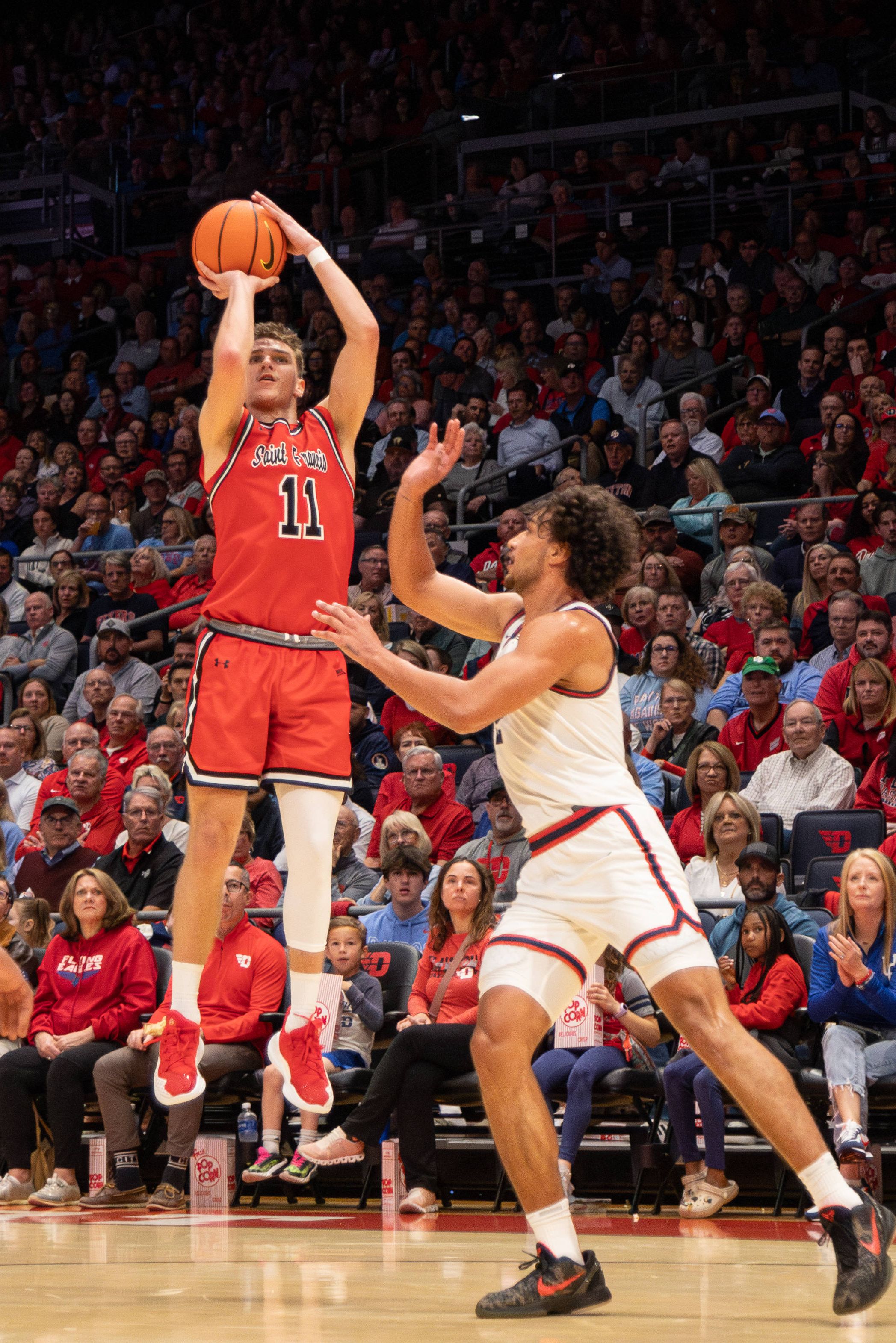 Photo of a man shooting a basketball during a game. 