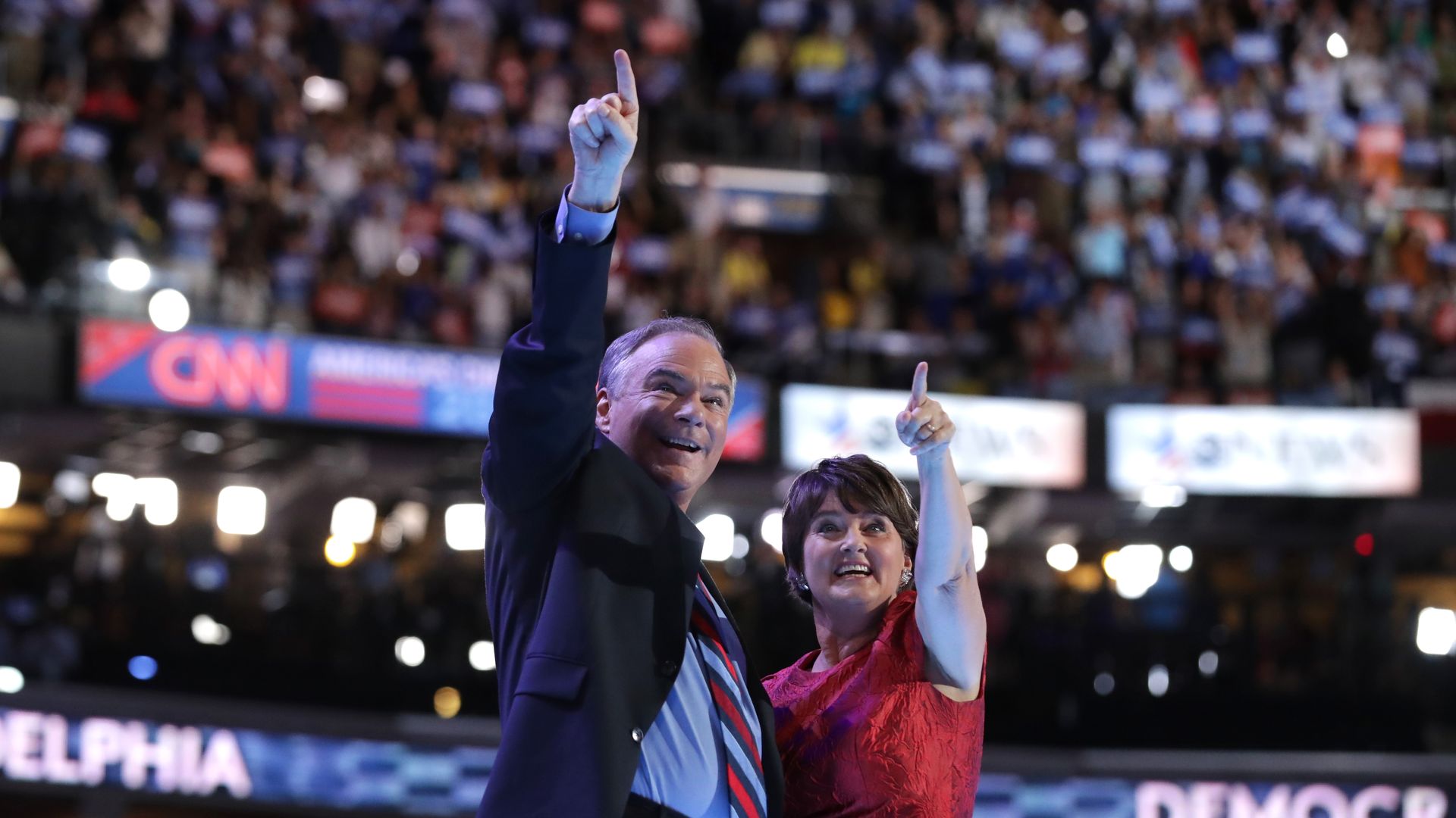 Sen. Tim Kaine and Anne Holton point upward while on stage at the 2016 Democratic National Convention.