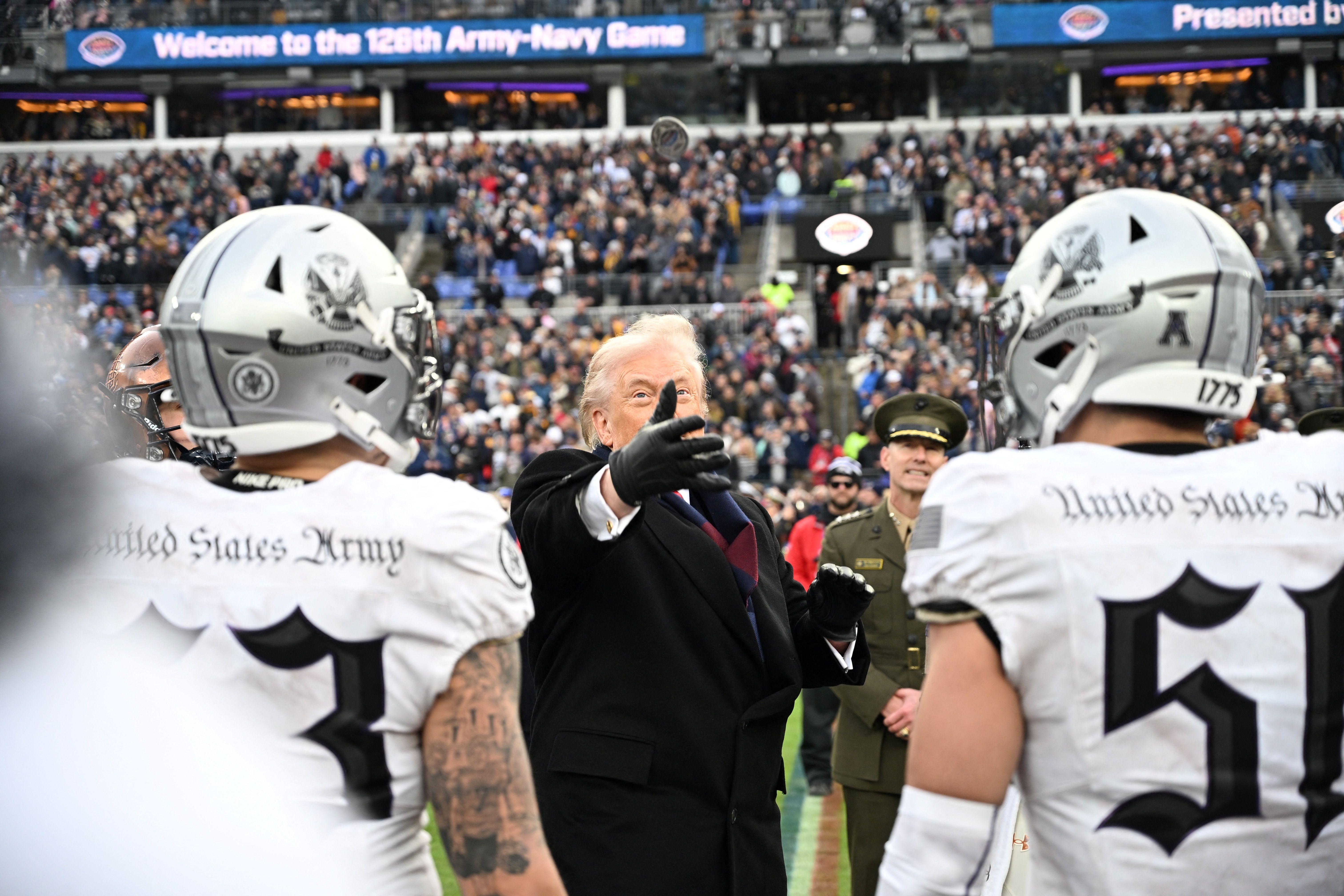  President Donald Trump tosses a coin before the college football game between the US Army and Navy at the M&T Bank Stadium in Baltimore, Maryland, on December 13, 2025. (Photo by Alex WROBLEWSKI / AFP via Getty Images)