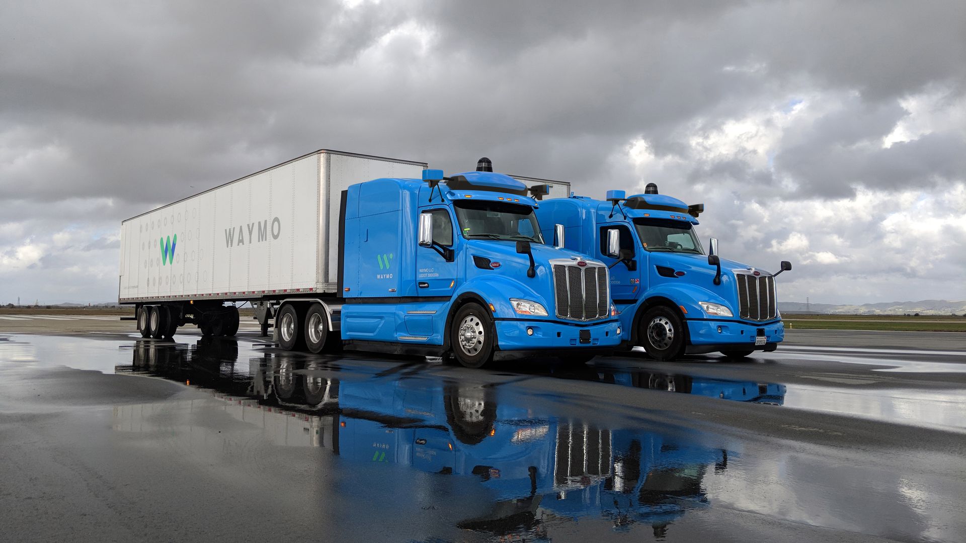 image of 2 commercial trucks operated by Waymo's self-driving technology