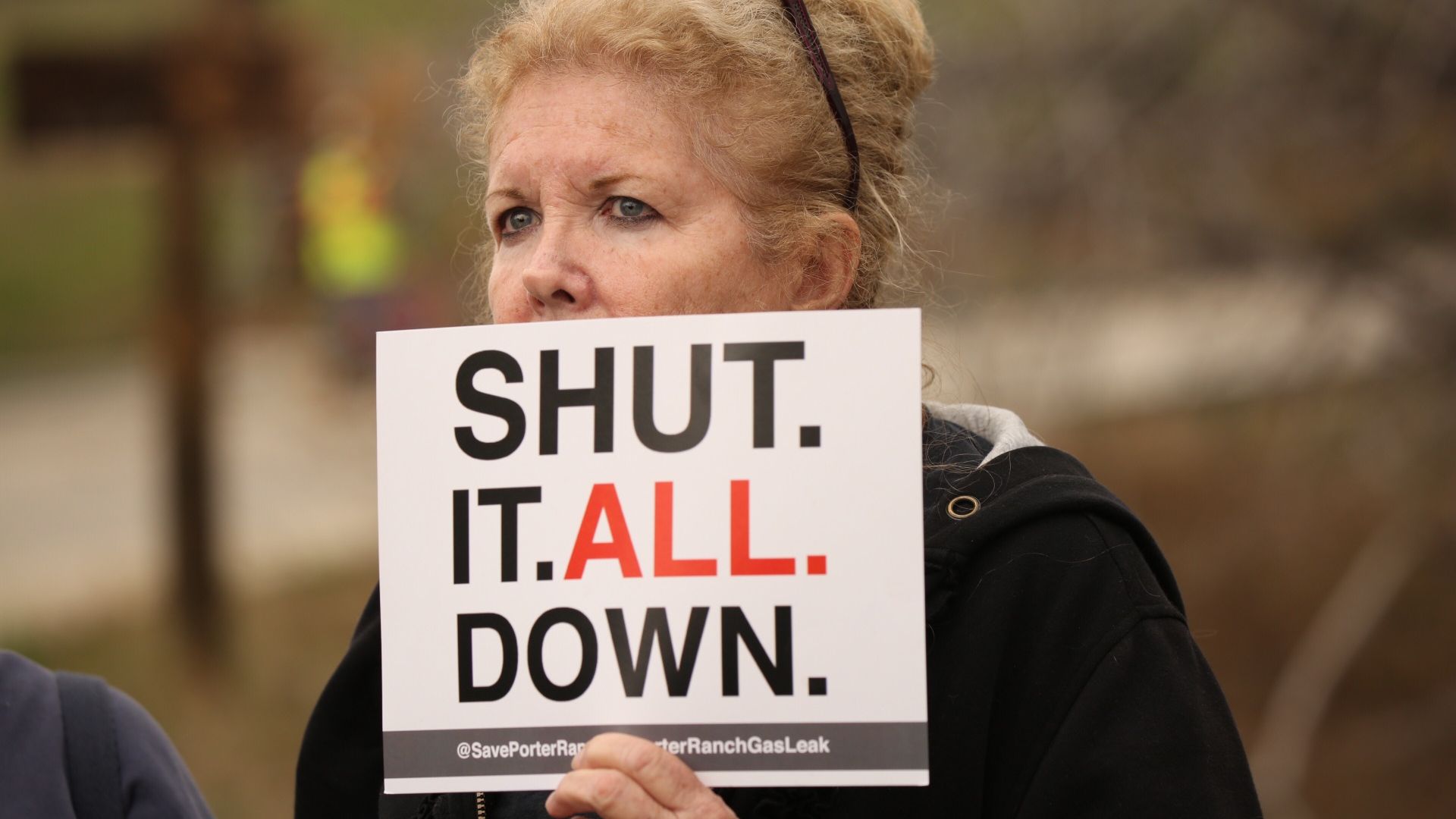 Local resident Maureen Capra holds sign as she listens to Rep. Brad Sherman, D-Sherman Oaks,