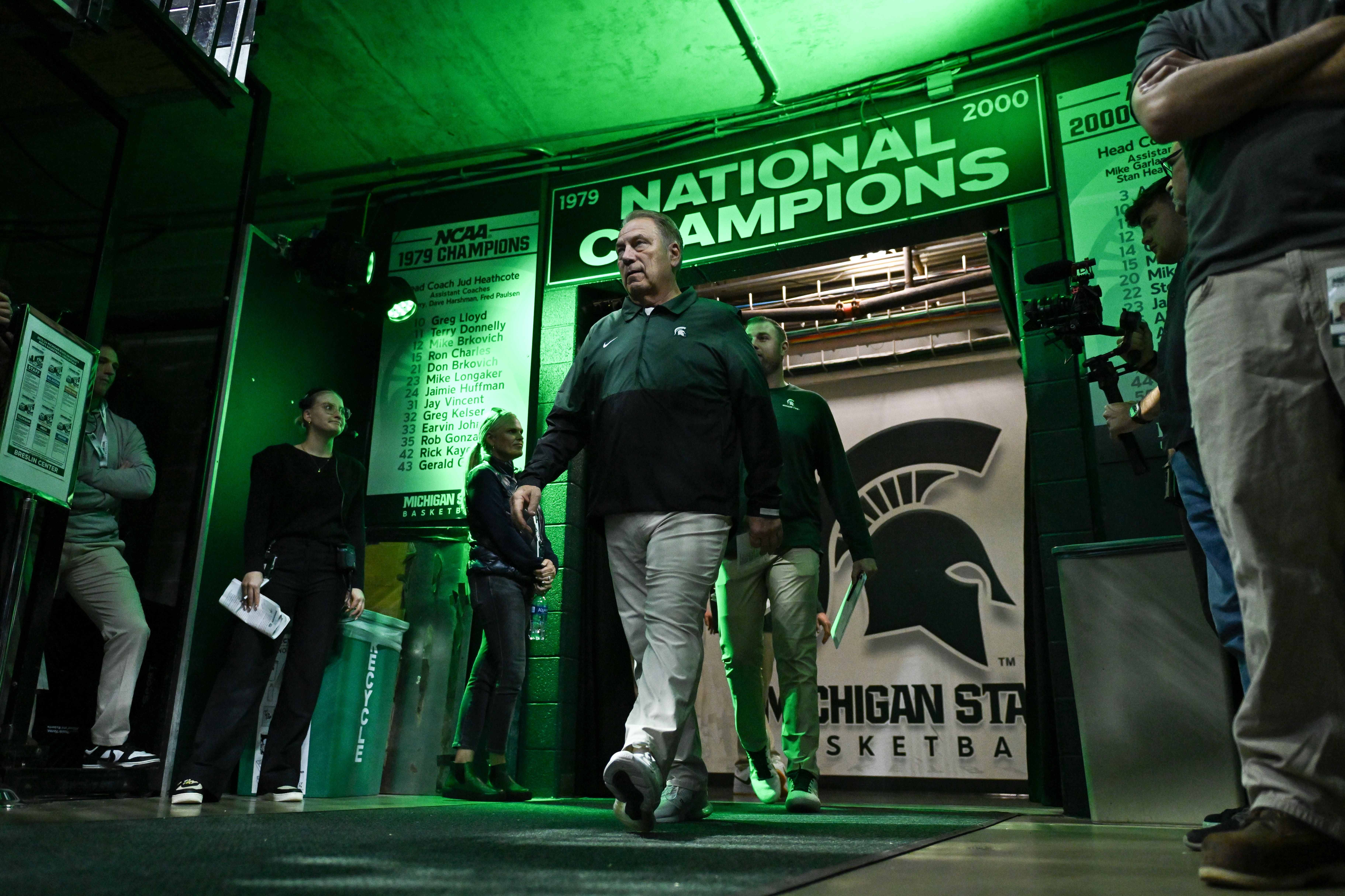 Photo of a coach walking onto a court with all green