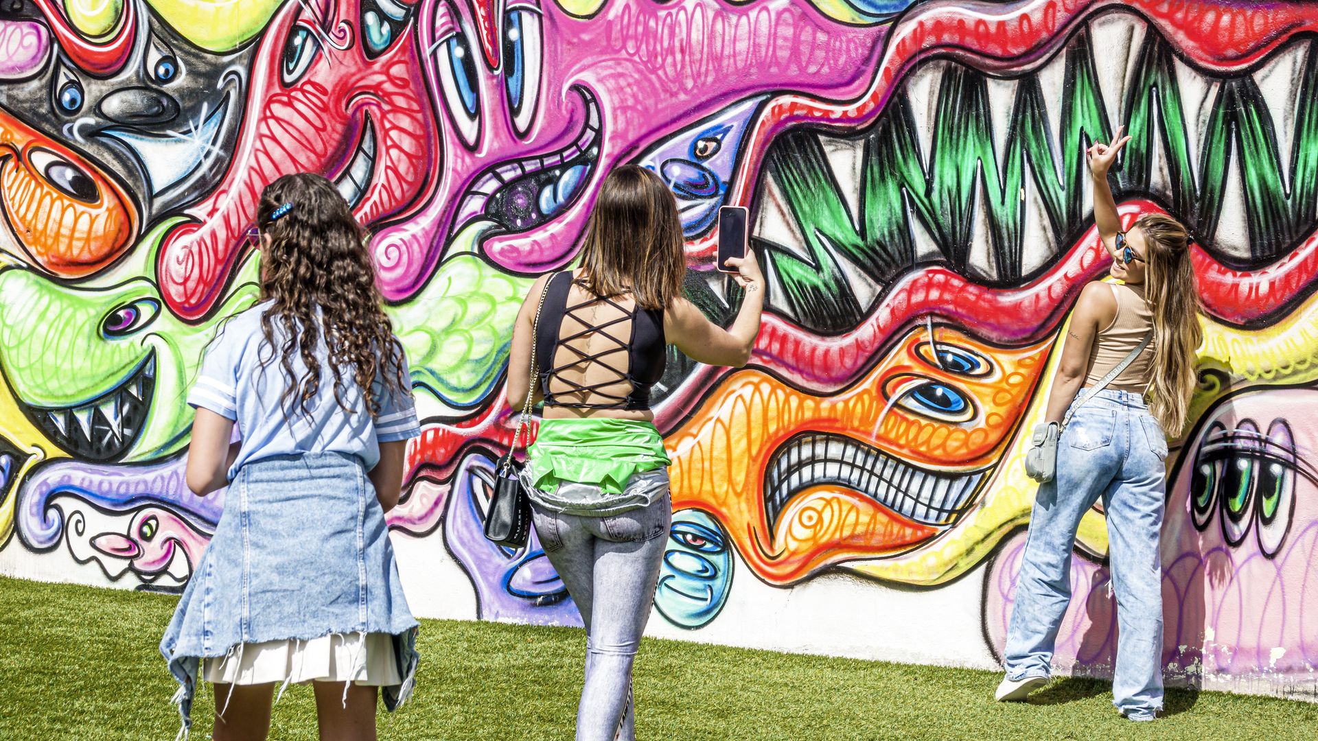 Teenagers taking photos in front of Wynwood Walls murals.
