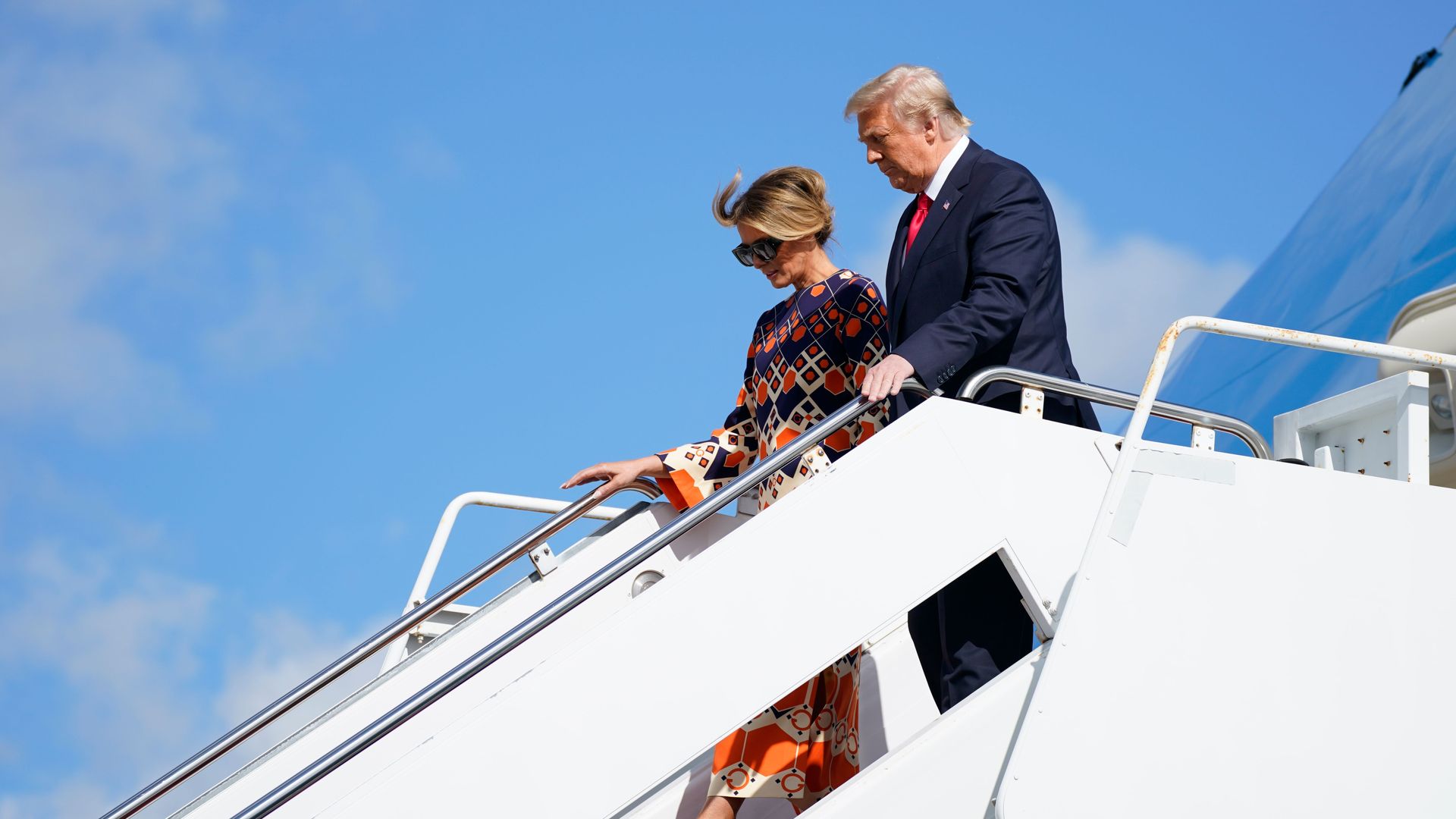 Donald and Melania Trump walk down 