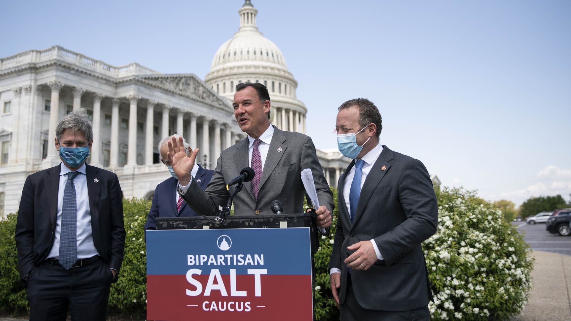 Lawmakers stand behind podium