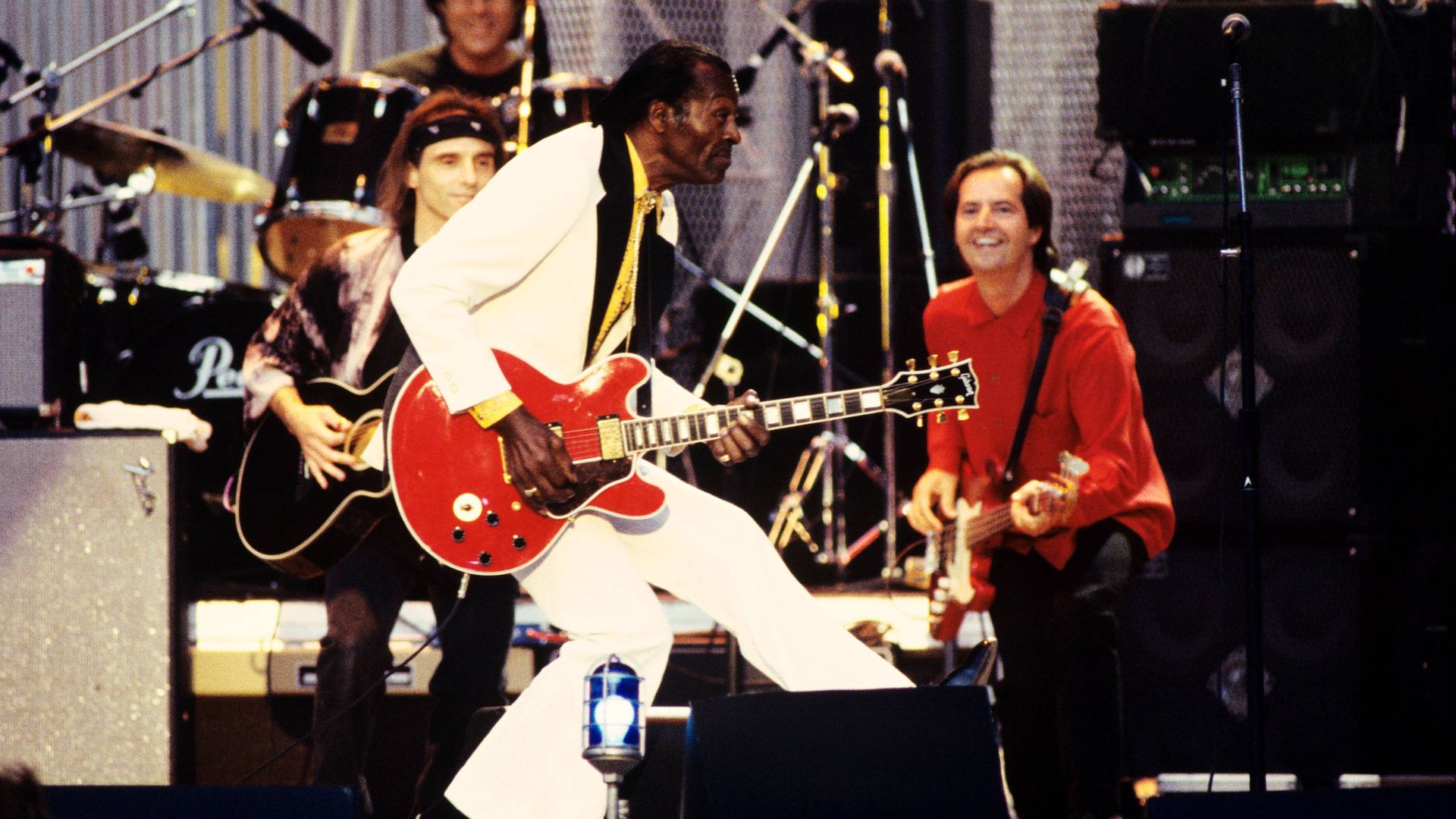 Chuck Berry does his iconic duck walk across a stage. 