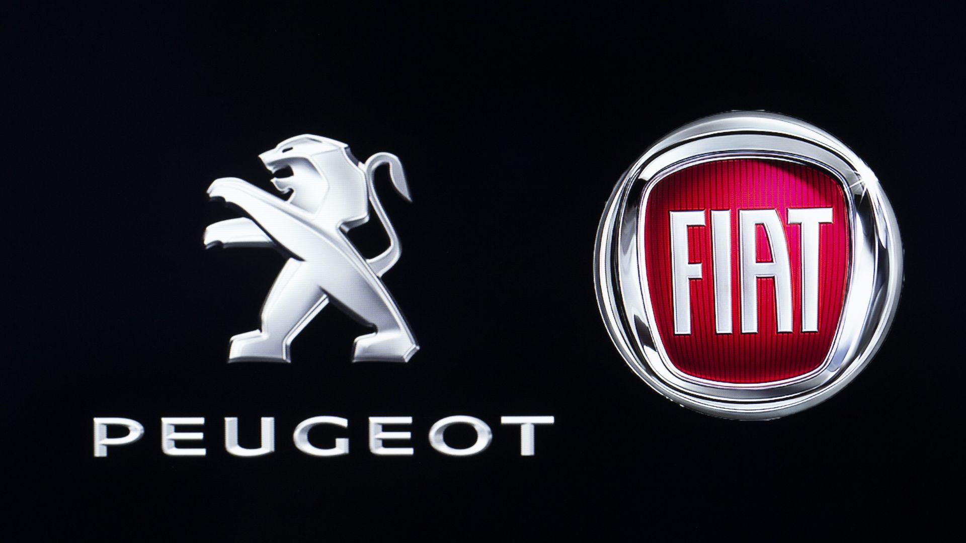 The logos of Fiat Automobiles and Peugeot sit on display in Ankara, Turkey