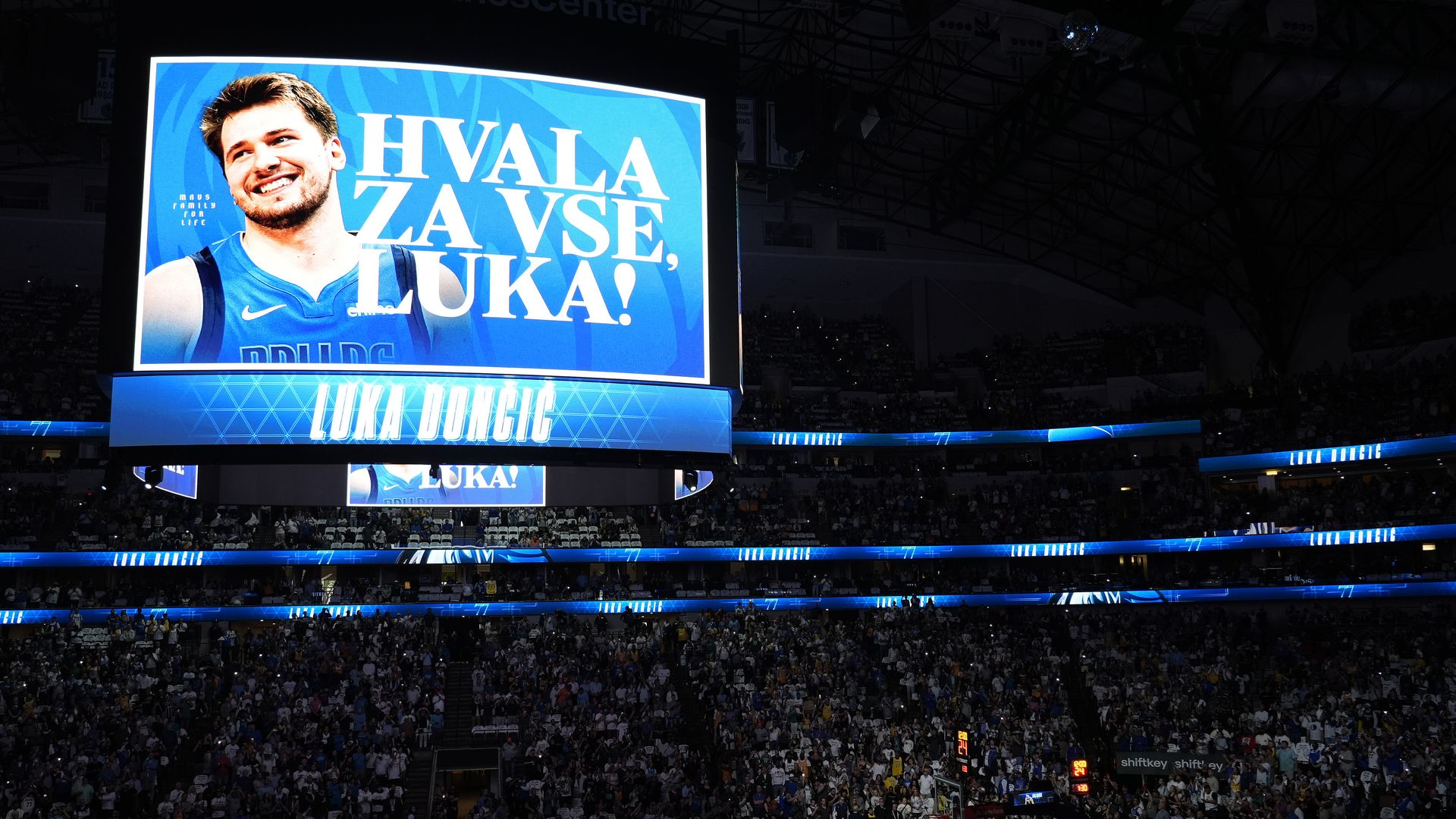 A blue sign saying "Hvala za vse Luka" in a basketball arena