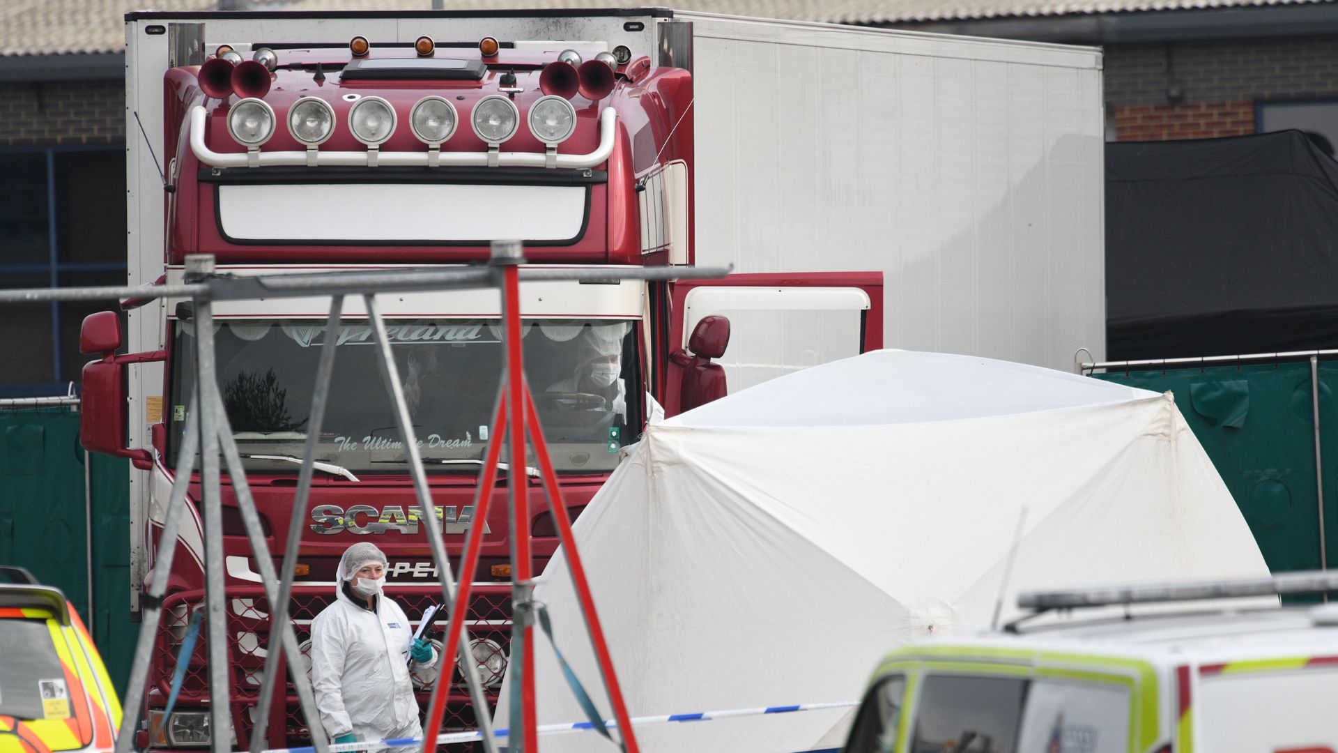 Forensic officers stand in front of the truck in which 39 bodies were discovered.