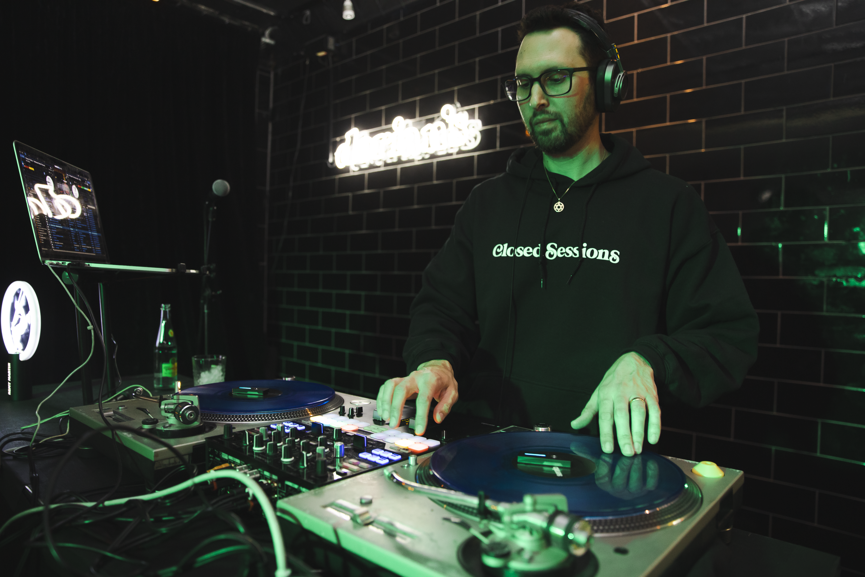 Photo of a man behind a mixing console playing records 