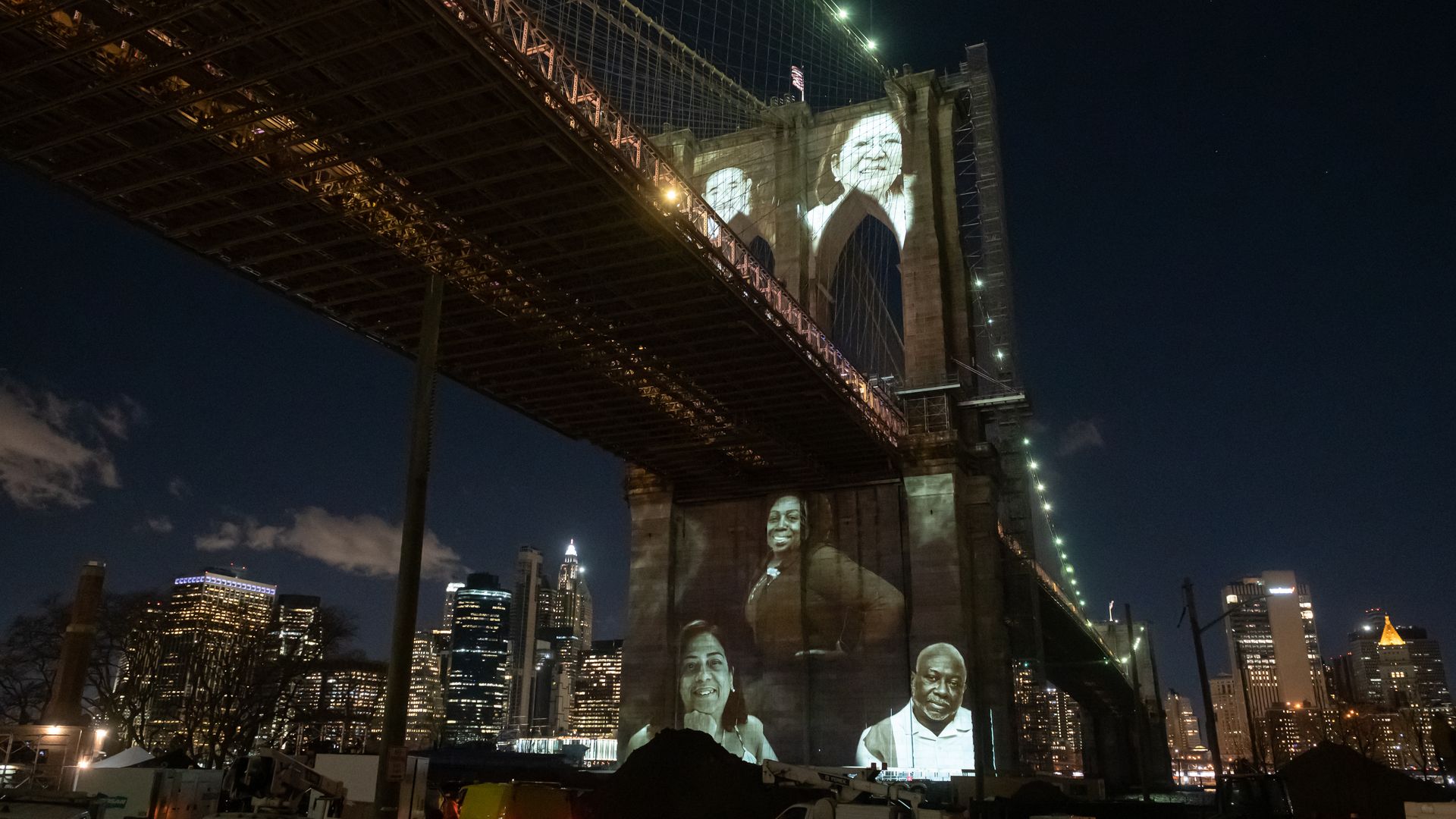 Photos of people who died from COVID-19 projected on the Brooklyn Bridge in New York City on March 14.