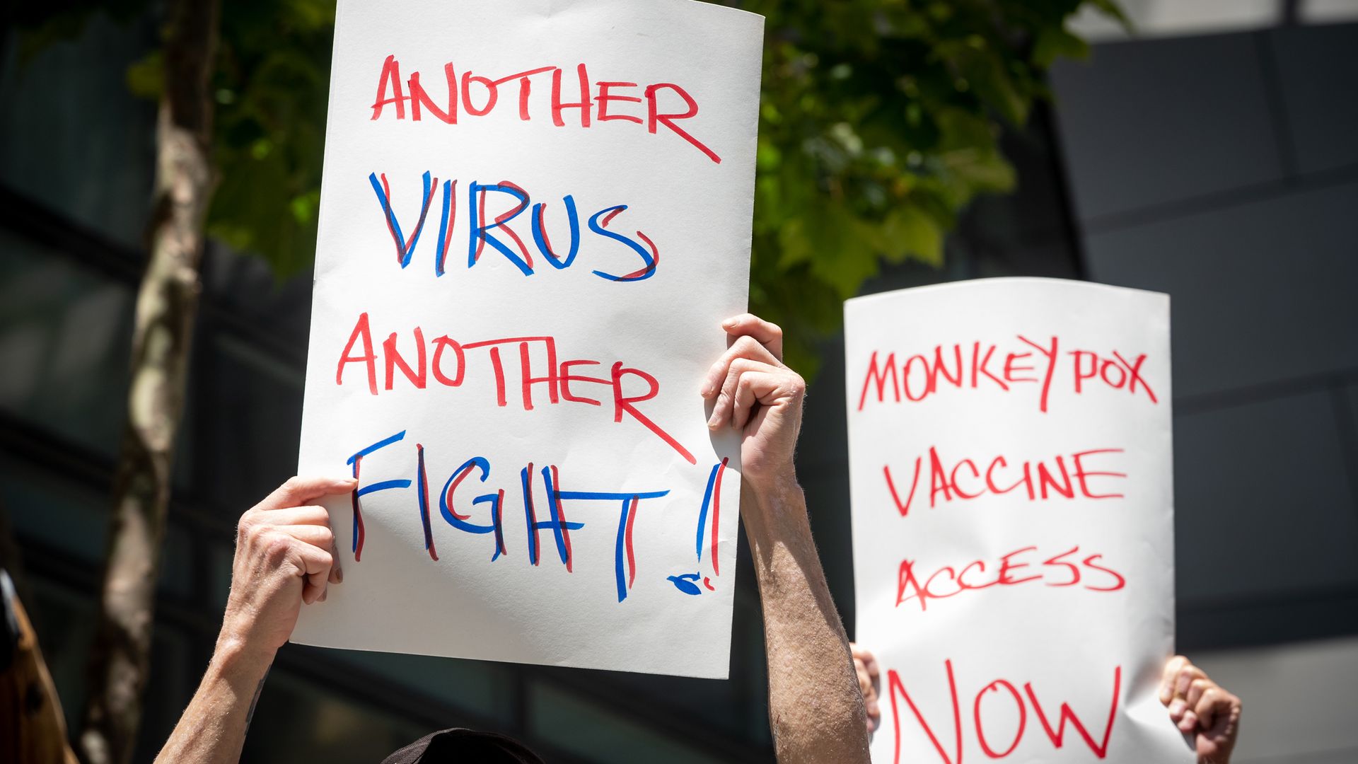 People hold signs during a rally to demand that the federal government respond quickly to the recent San Francisco monkeypox outbreak at the San Francisco Federal Building on July 18