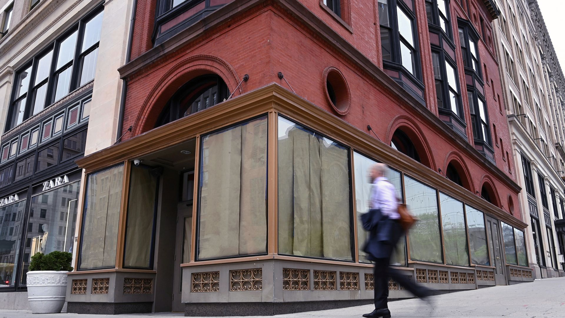 Man walks by closed storefront downtown