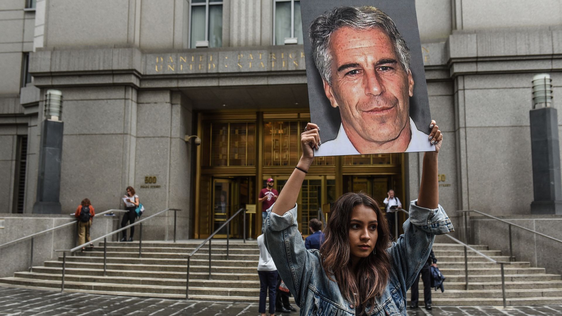 A protest group called "Hot Mess" hold up signs of Jeffrey Epstein in front of the federal courthouse on July 8, 2019 in New York City.