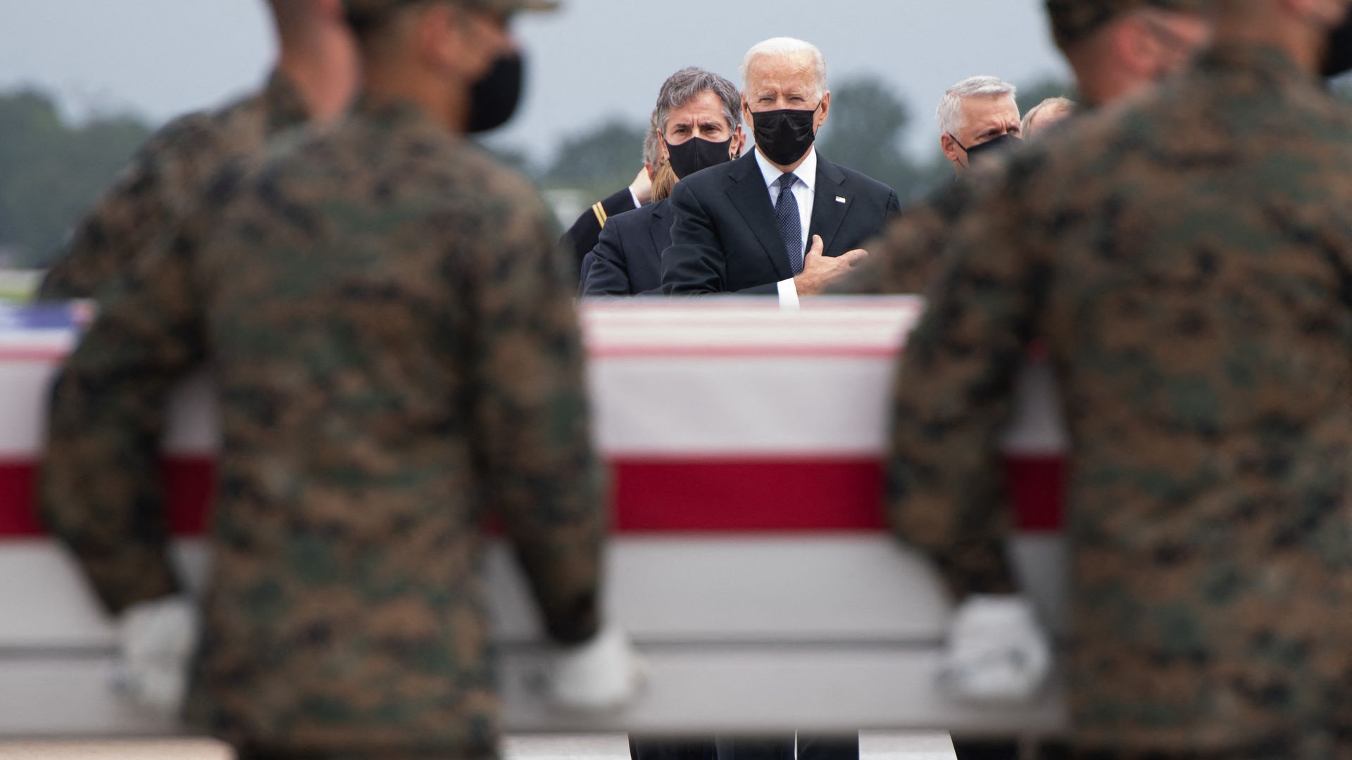 President Biden is seen looking at a flag-draped transfer case as the 13 service members killed in Kabul last week were returned to the U.S.