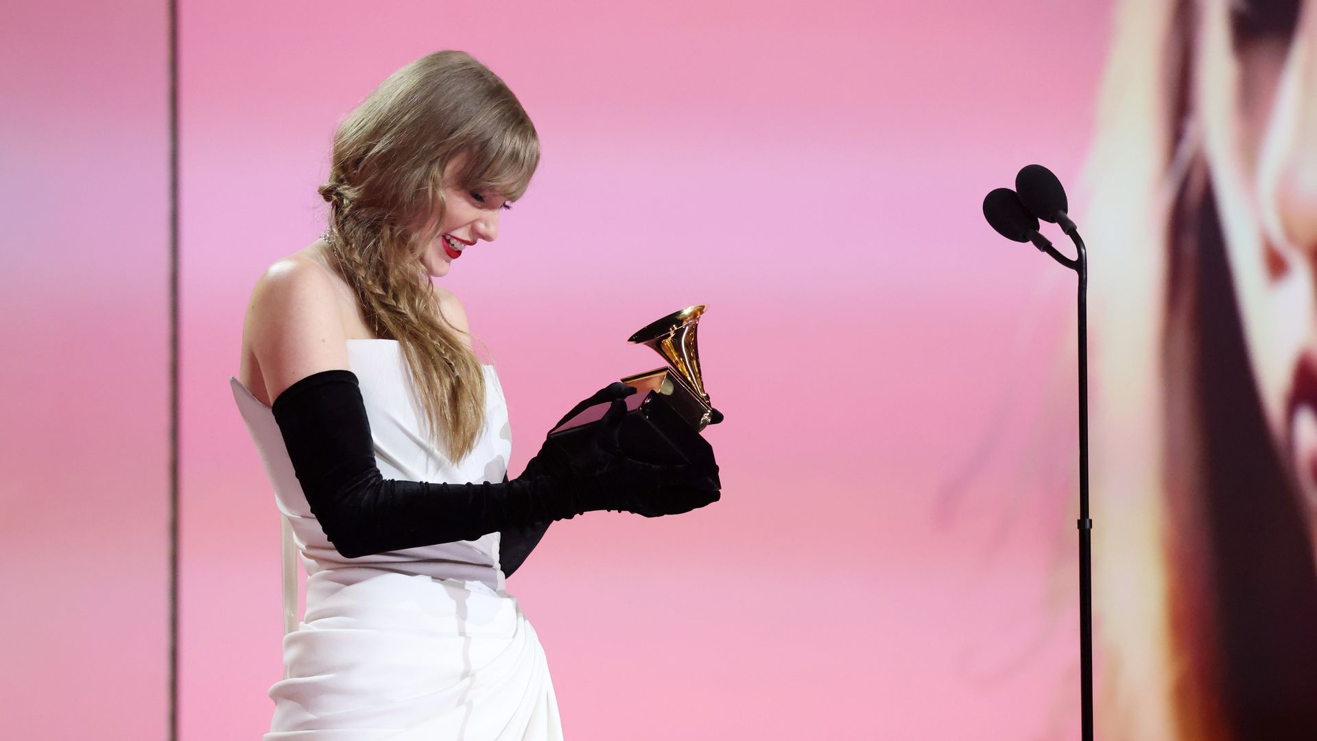 Taylor Swift receives a Grammy on stage. 