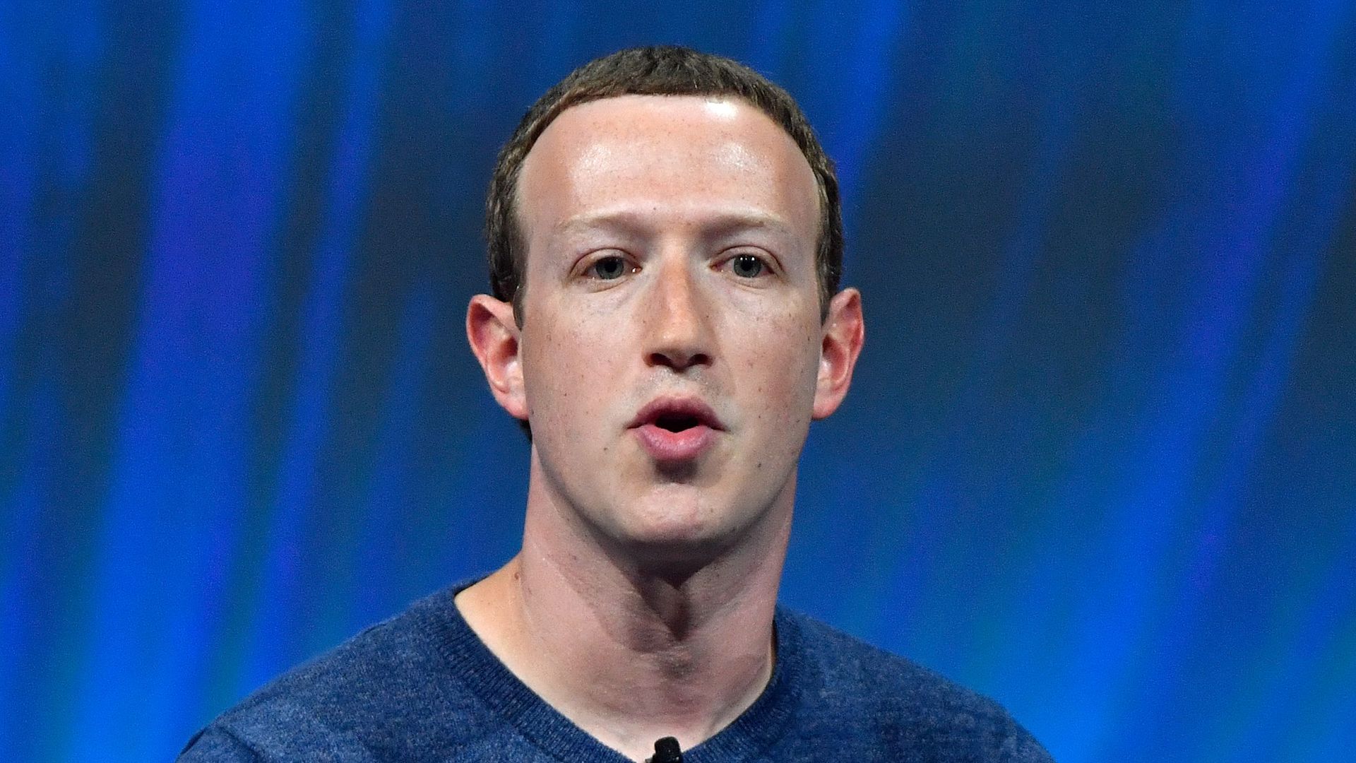 In this image, Mark Zuckerberg speaks into a microphone.